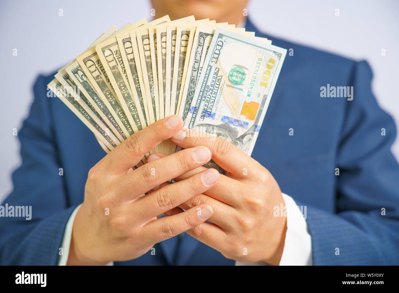 L'argent dans USA tenir en main business homme portant un costume bleu, payer USD, l'échange d'argent. Banque D'Images