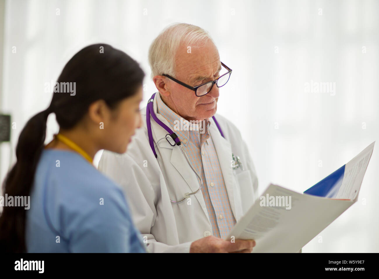 Médecin Senior consulting avec une jeune infirmière. Banque D'Images