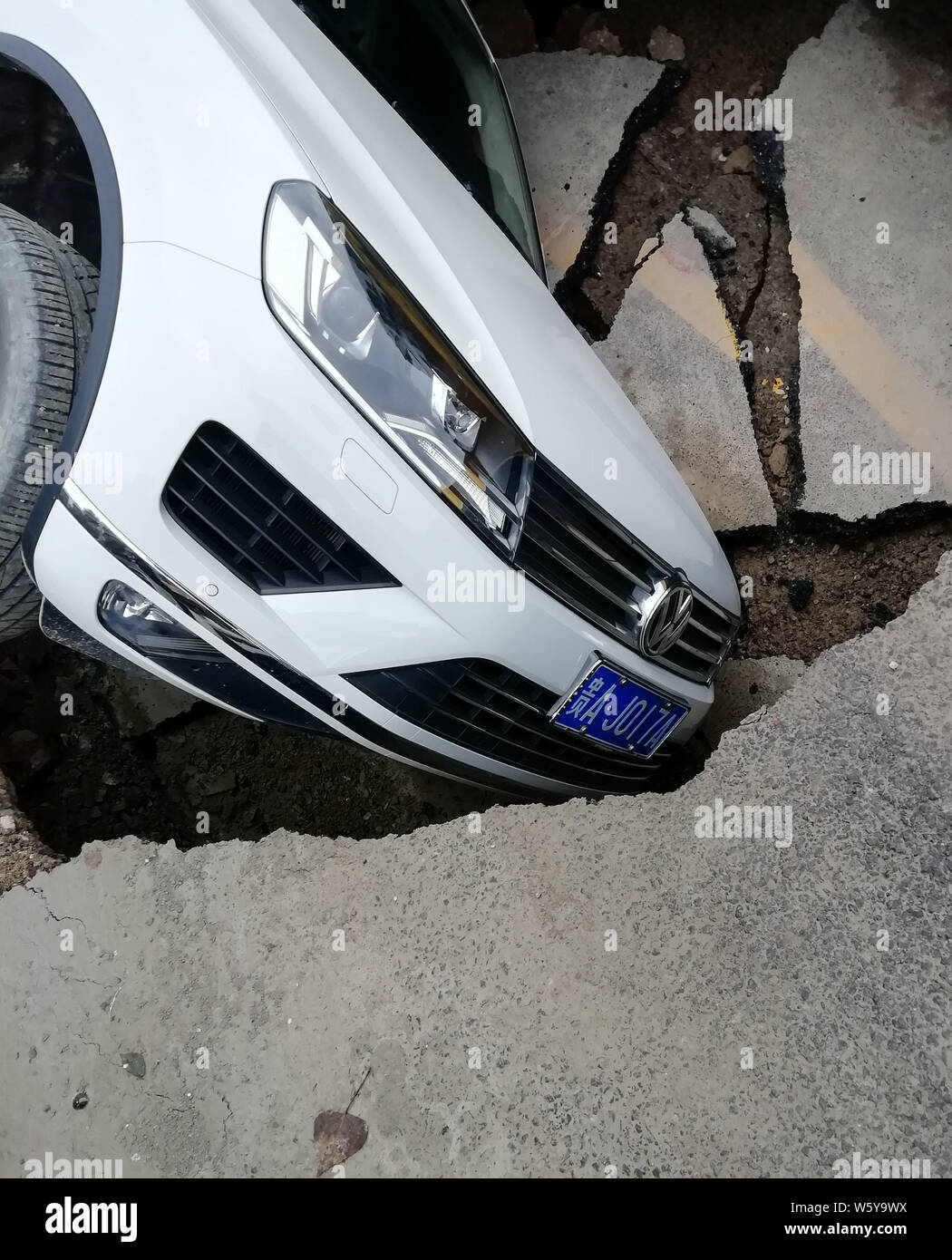 Deux véhicules sont piégés dans un gouffre après l'effondrement d'une route dans la région de Guiyang city, au sud-ouest de la province du Guizhou, Chine, 6 novembre 2018. Un gouffre qui Banque D'Images