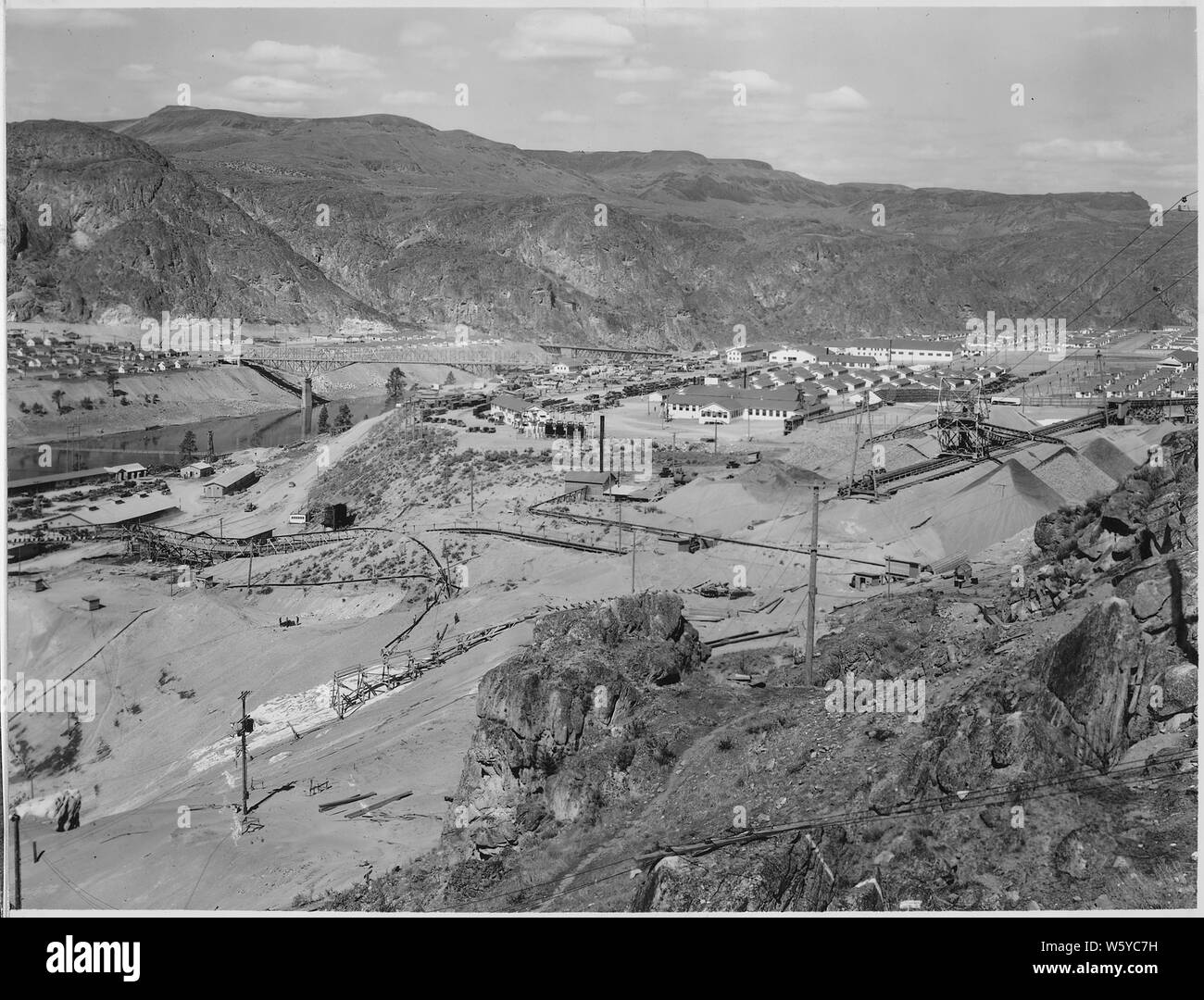 Trois-panorama du haut du pilier. Le Eastmix usine de béton en construction apparaît au centre premier plan. ; Portée et contenu : la photographie de deux volumes d'une série d'albums de photos documentant la construction du barrage de Grand Coulee et travaux connexes sur le bassin du Columbia Projet. Notes générales : Cette image fait partie d'une vue panoramique qui comprend les articles 1007, 1007-A, et 1007-B. L'image d'origine mesure environ 22 pouces de largeur. Banque D'Images