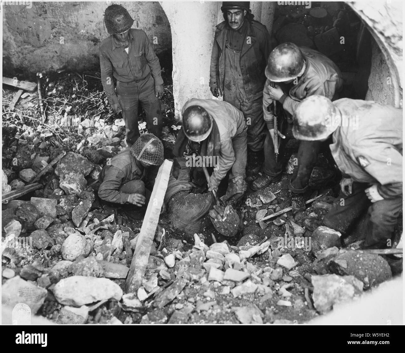 Des soldats américains commencent à découvrir un camarade qui a été enterré dans les décombres d'un immeuble touché par une bombe lors d'une attaque aérienne nazie dans la zone, Italie Cerasuolo Banque D'Images