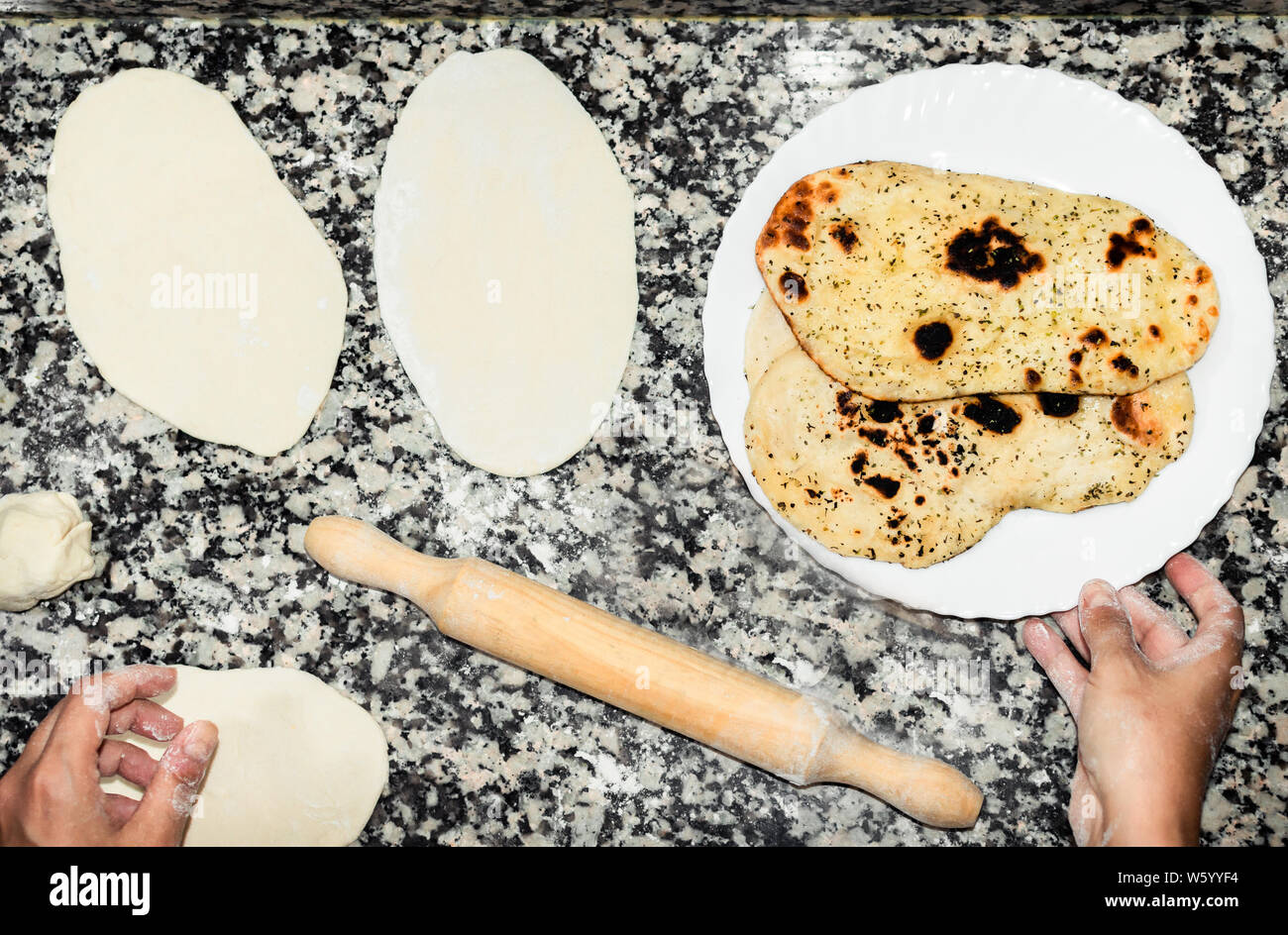 Chef de la préparation des Naan indien ou asiatique, du pain. Processus de préparation, la pâte sur une table de cuisine et de délicieux pains prêt à manger sur le plat blanc. Banque D'Images