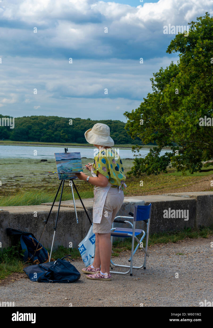 La peinture de l'artiste féminine la scène dans Chichester Harbour, Chichester, West Sussex, Angleterre, Royaume-Uni Banque D'Images