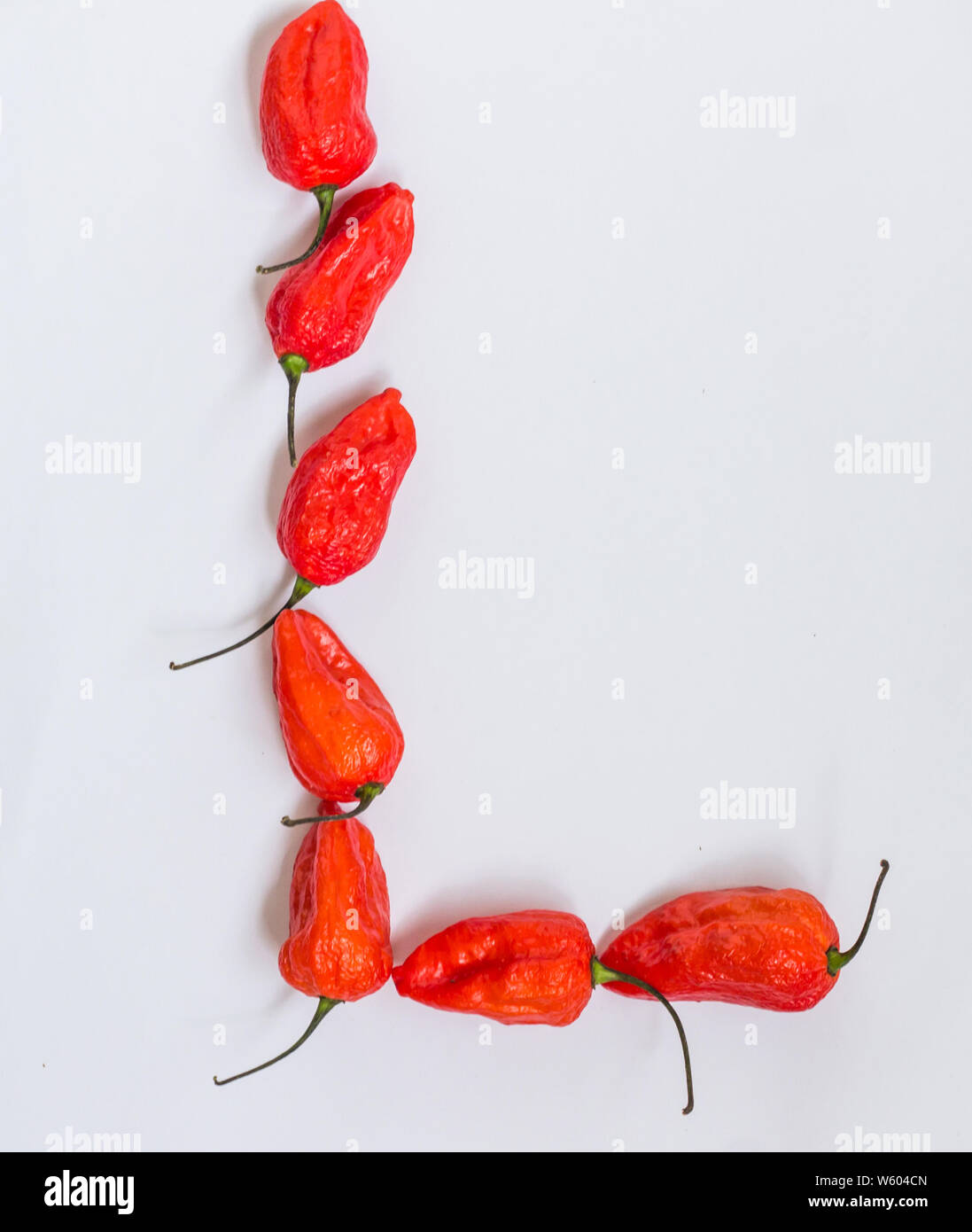 Lettre L'alphabet fait avec Ghost pepper jolokia Bhoot over white background Banque D'Images