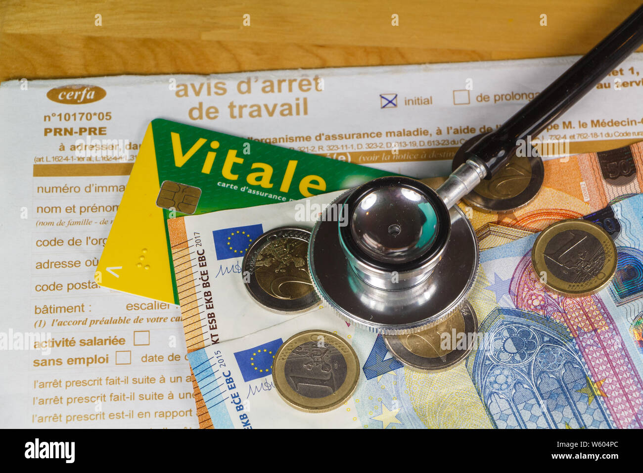 Avis d'arrêt de travail médical à partir de la france, carte vitale, noir stéthoscope, pièces et billets en euro Banque D'Images