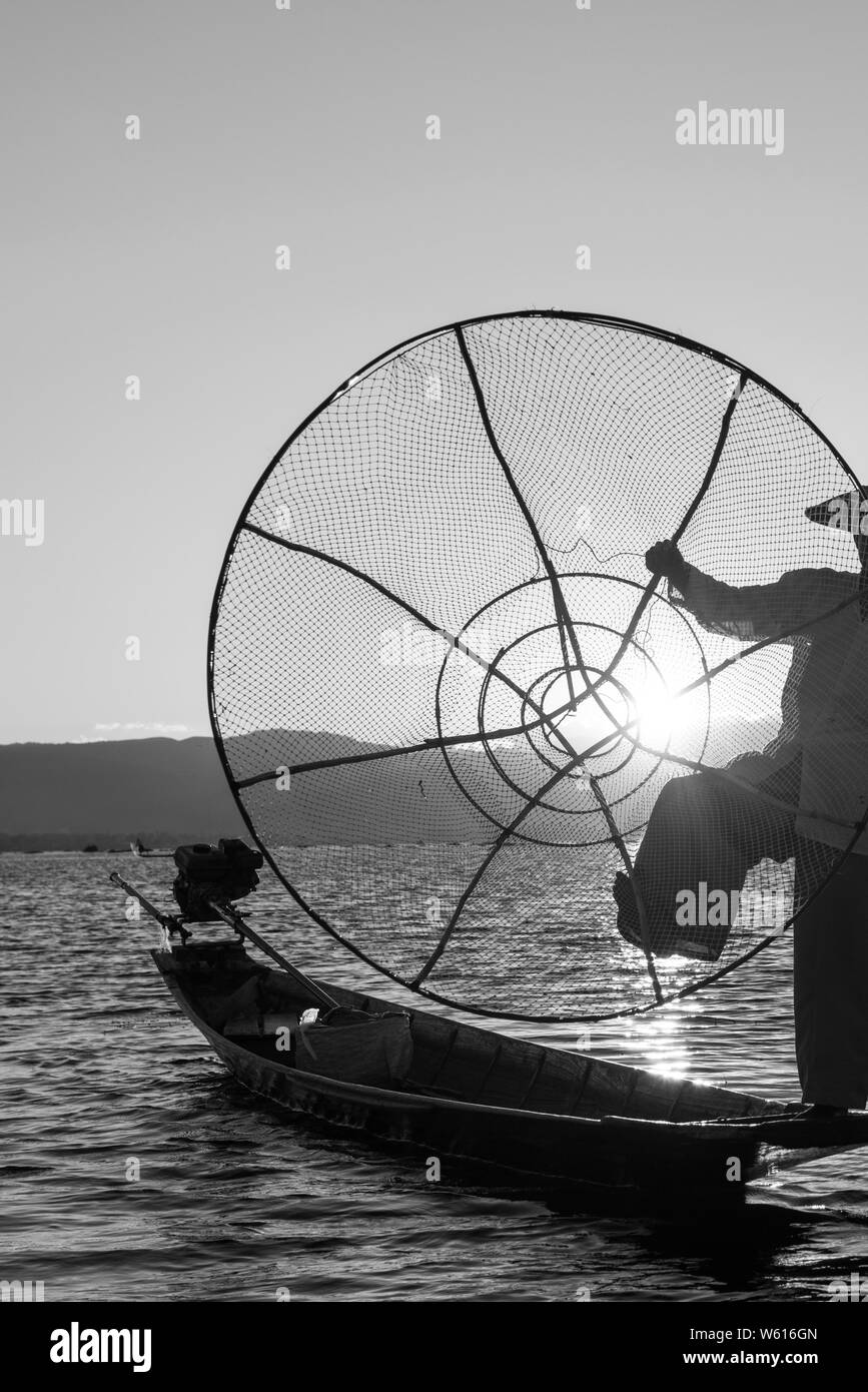 Photo noir et blanc de traditionnels birmans silhouette net contraste avec le coucher du soleil à Lac Inle, Myanmar Banque D'Images