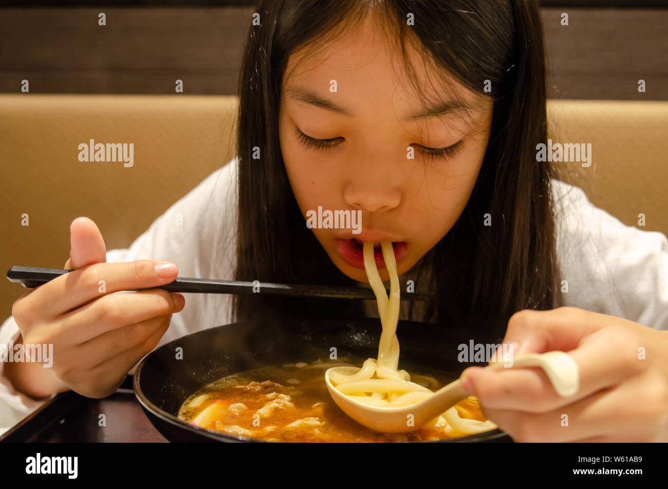 Asian girl eating ramen, nourriture Japonaise Banque D'Images