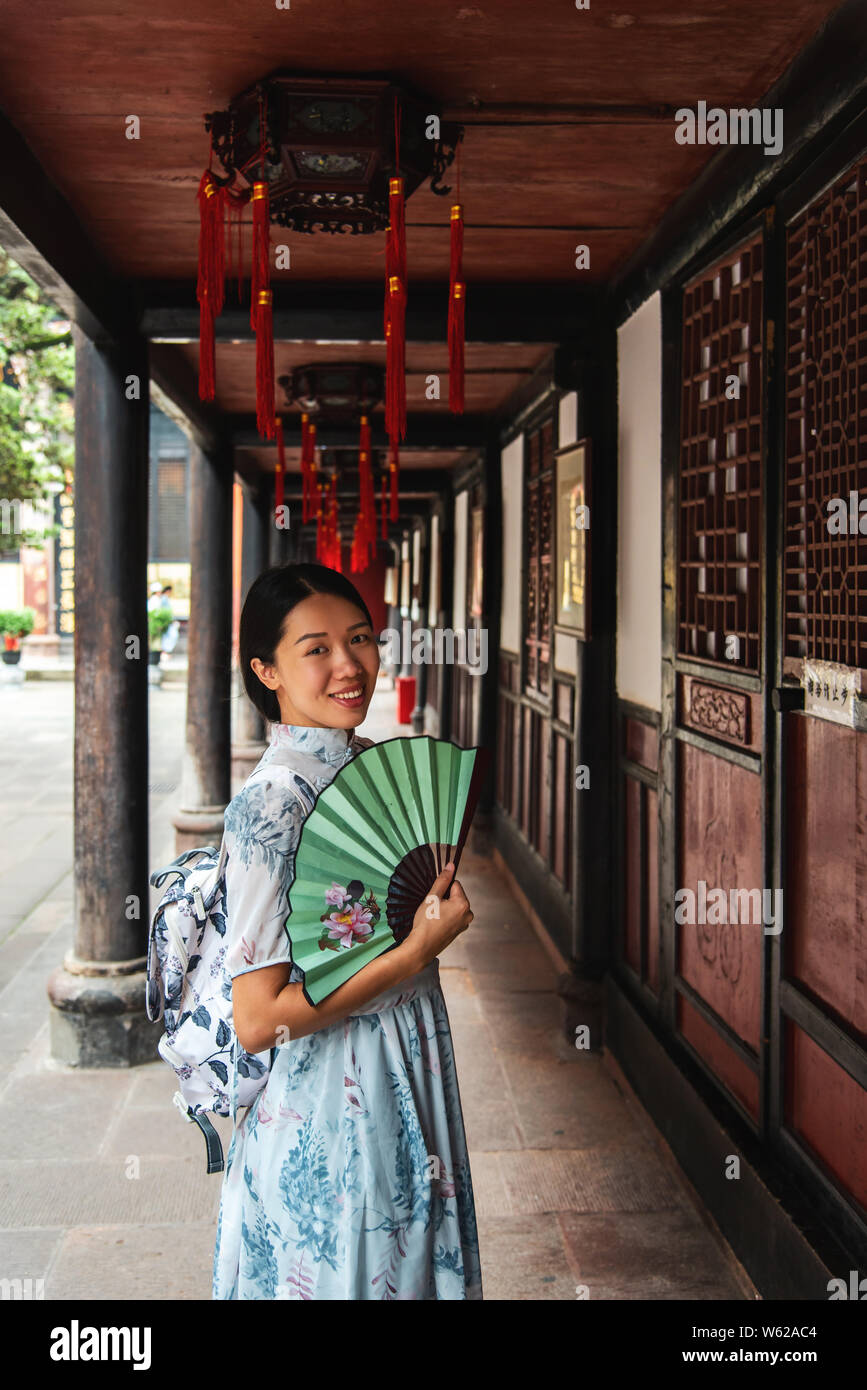 Femme Asiatique dans un temple tenant un portrait de ventilateur à main Banque D'Images