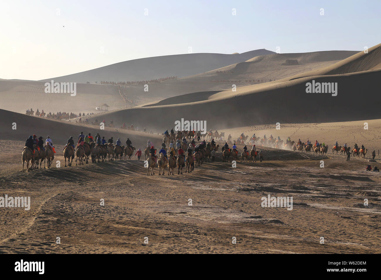 Les touristes monter des chameaux dans le désert de Gobi dans le Croissant de lune (Yueyaquan) et le chant des montagnes de sable dans endroit pittoresque ville de Dunhuang, dans les C Banque D'Images
