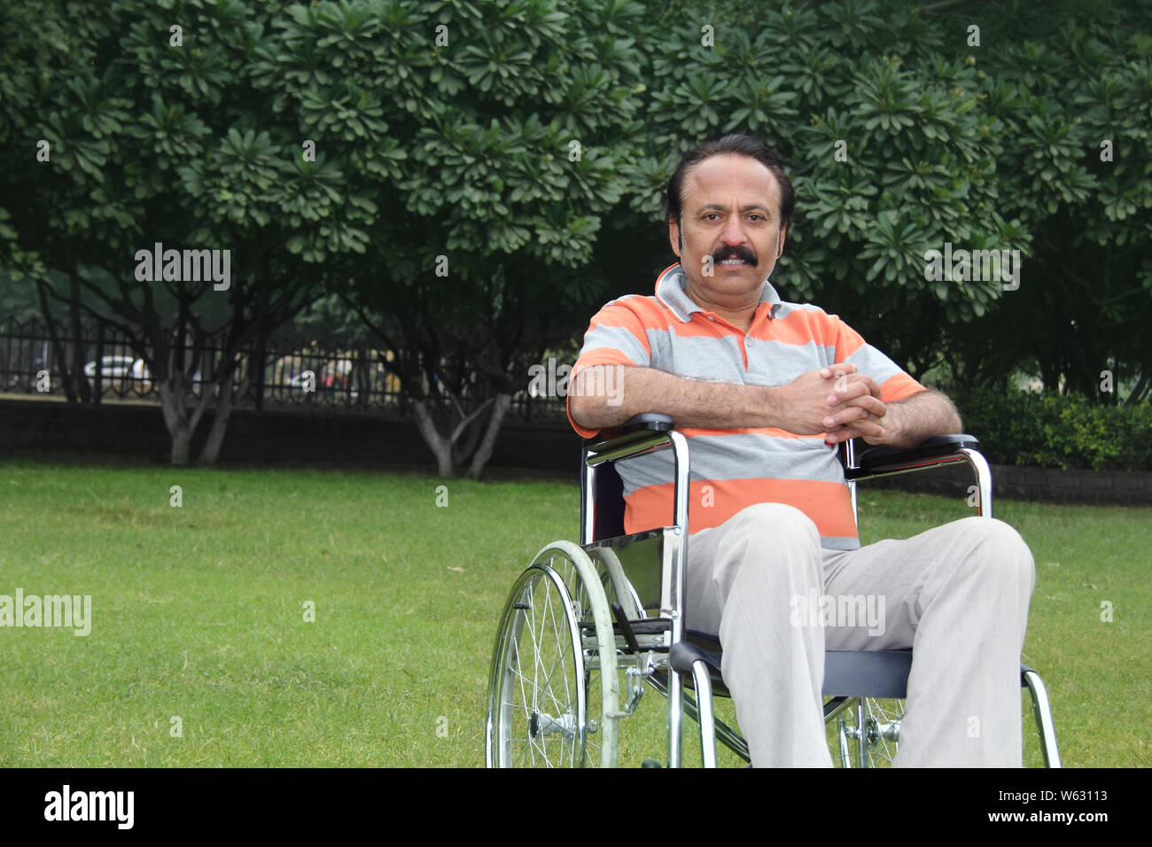 Homme assis dans un fauteuil roulant Banque D'Images