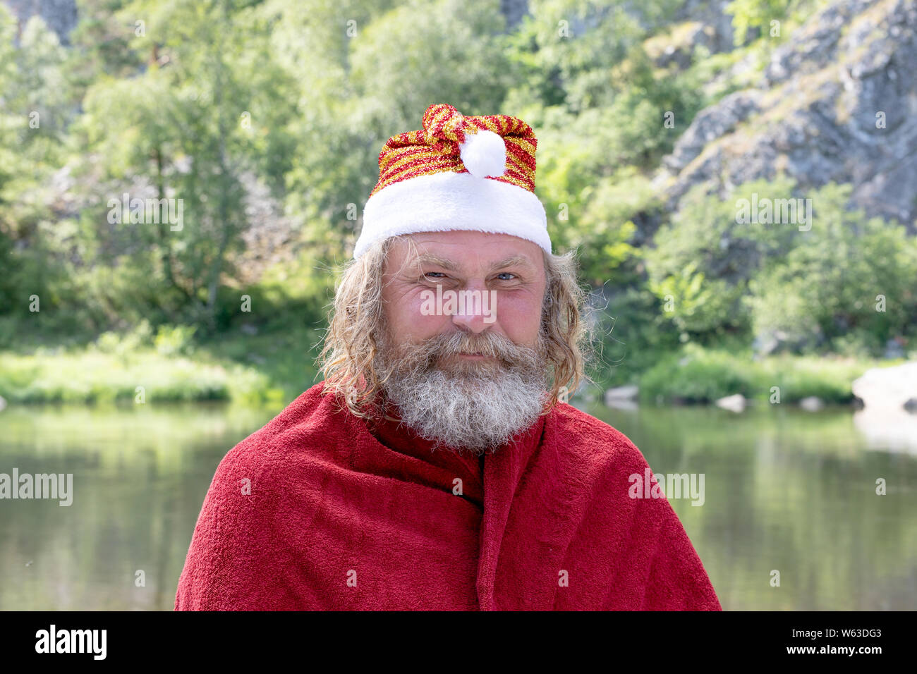 Portrait of a smiling man charismatique avec une barbe habillé en père Noël en nature background Banque D'Images