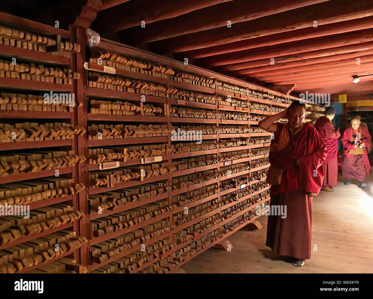 Lamas à pied au cours des plaques d'impression, Maison Sutra-Printing Dege, ou Dege Parkhang les écritures anciennes maison d'impression à l'intérieur du monastère Gengqing en t Banque D'Images