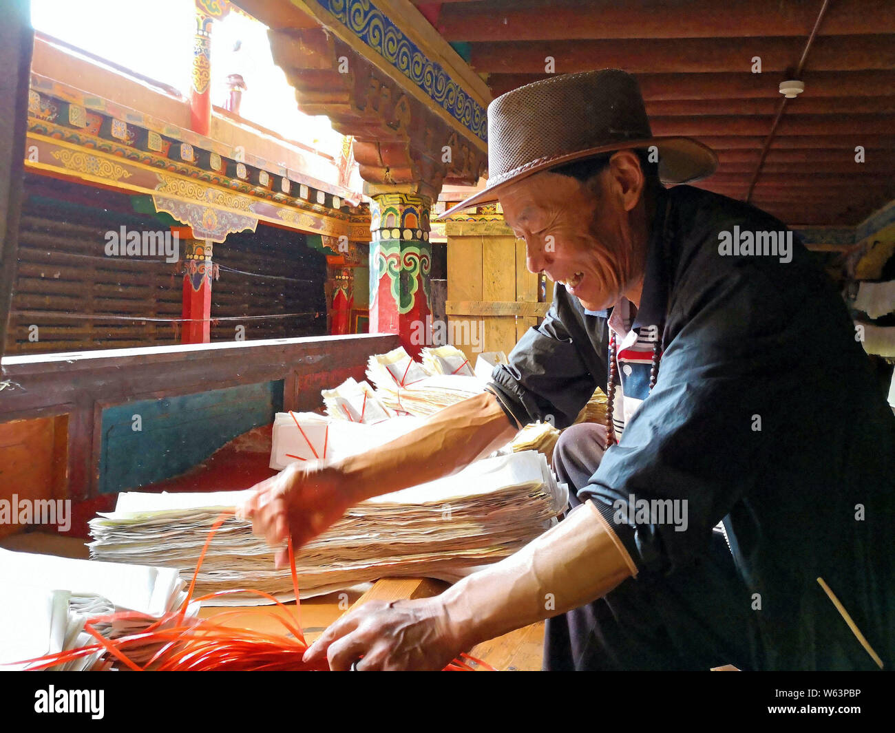 Un travailleur est le tri des pages imprimées à la maison Sutra-Printing Dege, ou Dege Parkhang les écritures anciennes maison d'impression à l'intérieur de l'Gengqing Monaster Banque D'Images