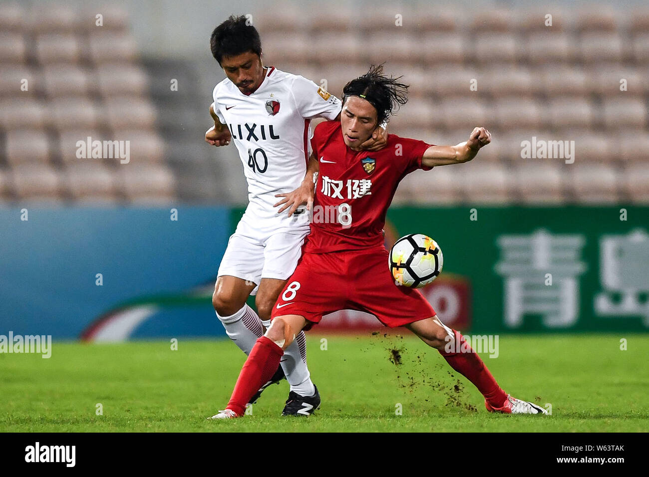 Zhang Xiuwei, droite, de la Shanghai Quanjian défis Mitsuo Ogasawara de Kashima Antlers du Japon en quart de leur 2e match de la jambe au cours de la Banque D'Images