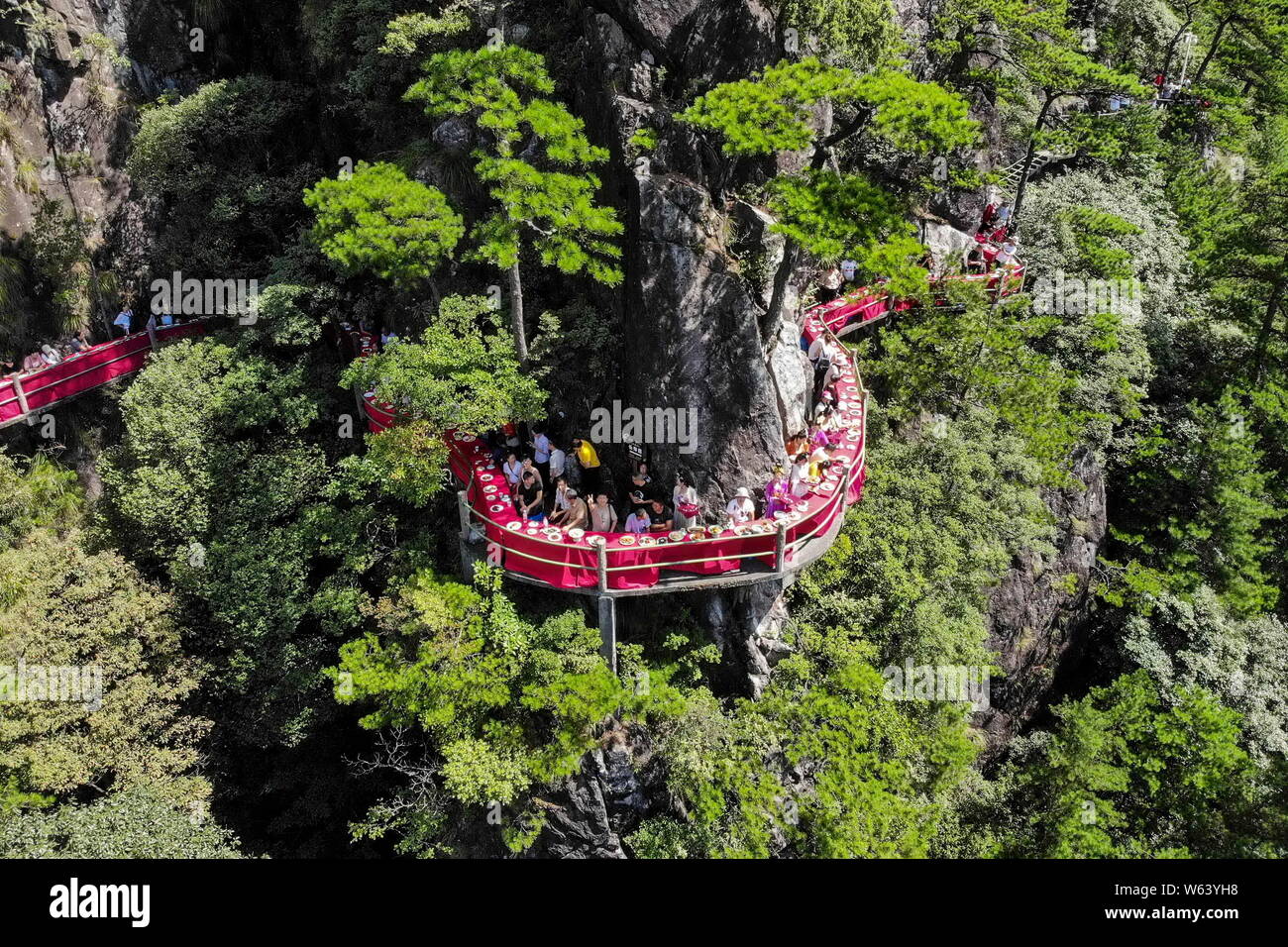 Diners d'admirer le paysage et les délices à un banquet tenu sur le bord d'une falaise à une falaise au restaurant de montagne Longquan à Lishui ville, Banque D'Images