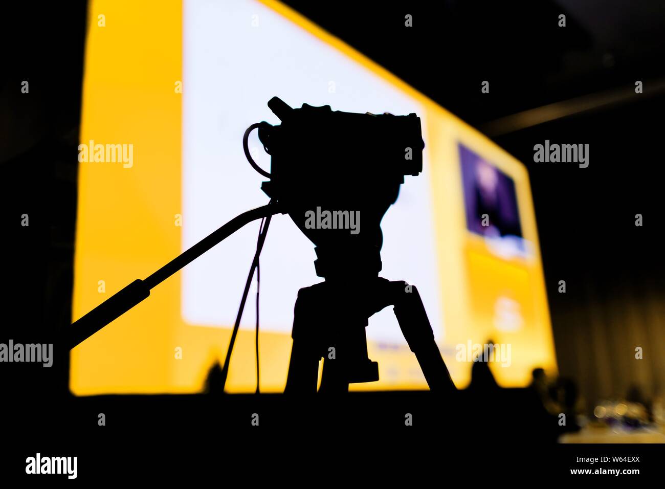 Conférence de Tournage avec caméra vidéo, silhouette de petit appareil photo d'un côté contre l'écran Banque D'Images
