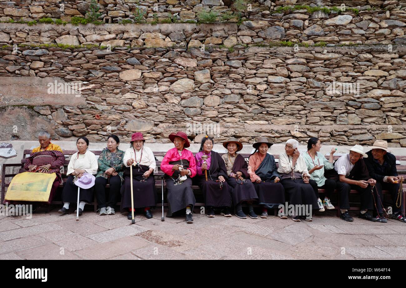 Les Tibétains locaux reste en face de la maison Sutra-Printing Dege, ou Dege Parkhang les écritures anciennes maison d'impression à l'intérieur du monastère Gengqing je Banque D'Images