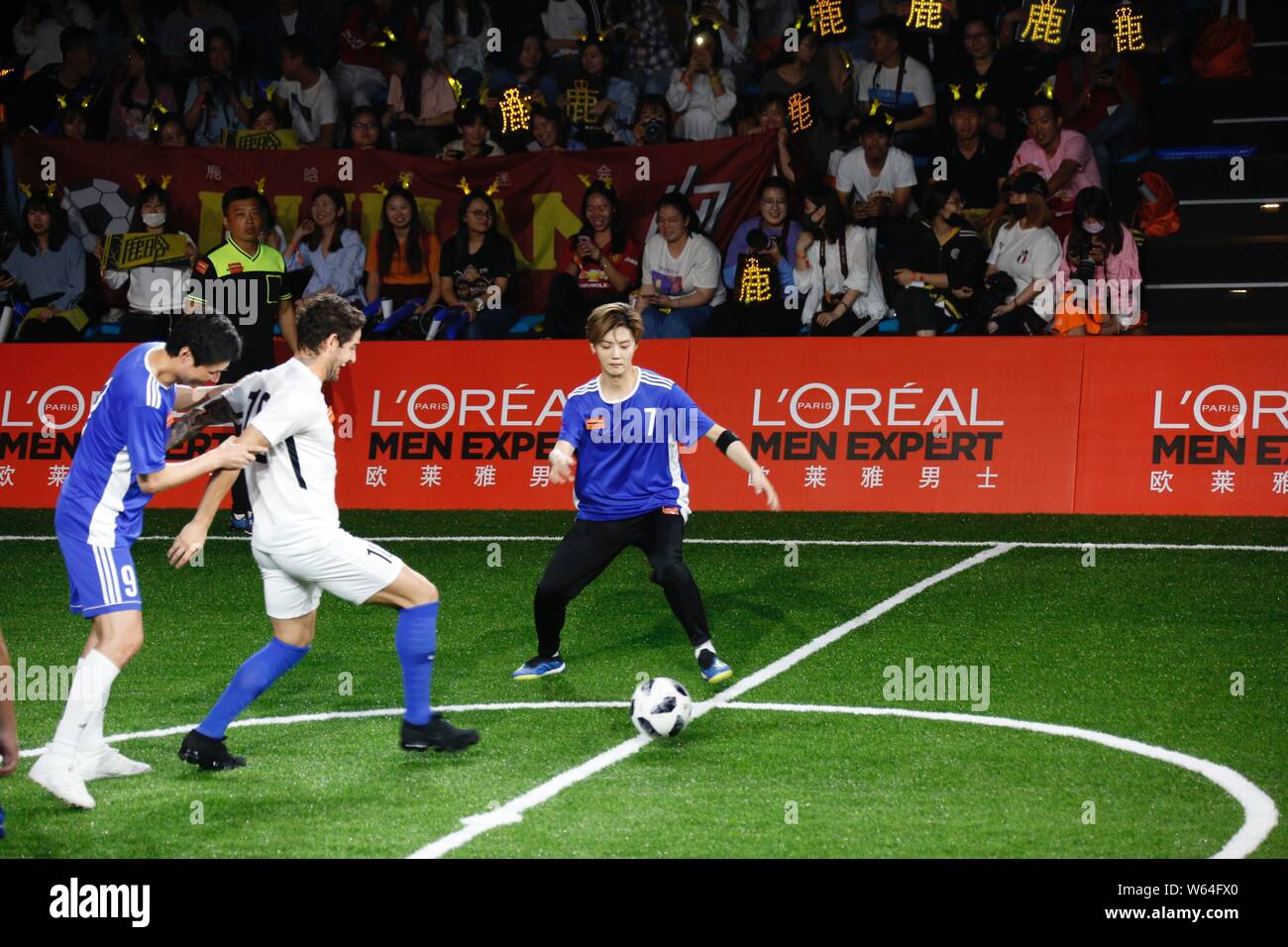 L'acteur et chanteur chinois Lu Han, droite, passe le ballon contre le joueur de football brésilien, Alexandre Rodrigues da Silva, connu sous le nom de Pato, au cours de l'Ou Banque D'Images