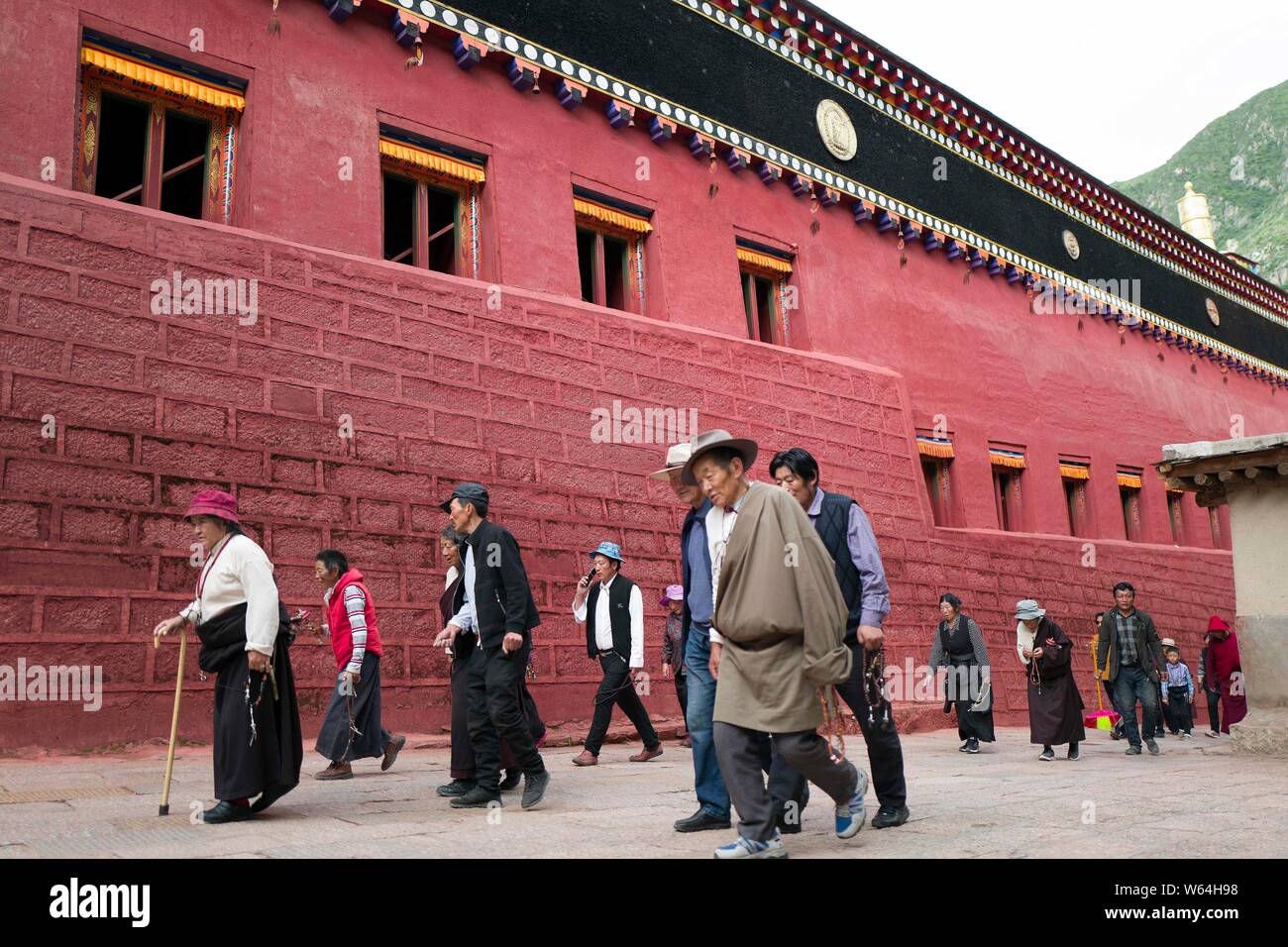 Les Tibétains locaux et touristes passent devant la maison Sutra-Printing Dege, ou Dege Parkhang les écritures anciennes maison d'impression à l'intérieur de l'Gengqing Monas Banque D'Images