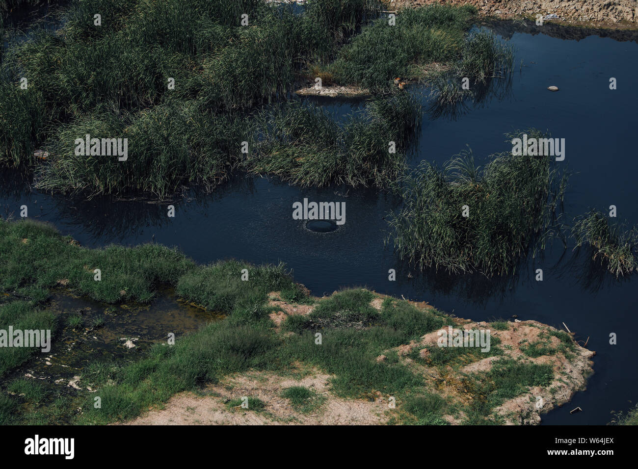 Vue aérienne de la pollution de l'eau rejetée par une station d'épuration des eaux usées pour former un immense étang près de l'habitation à Wuhan, centra Banque D'Images