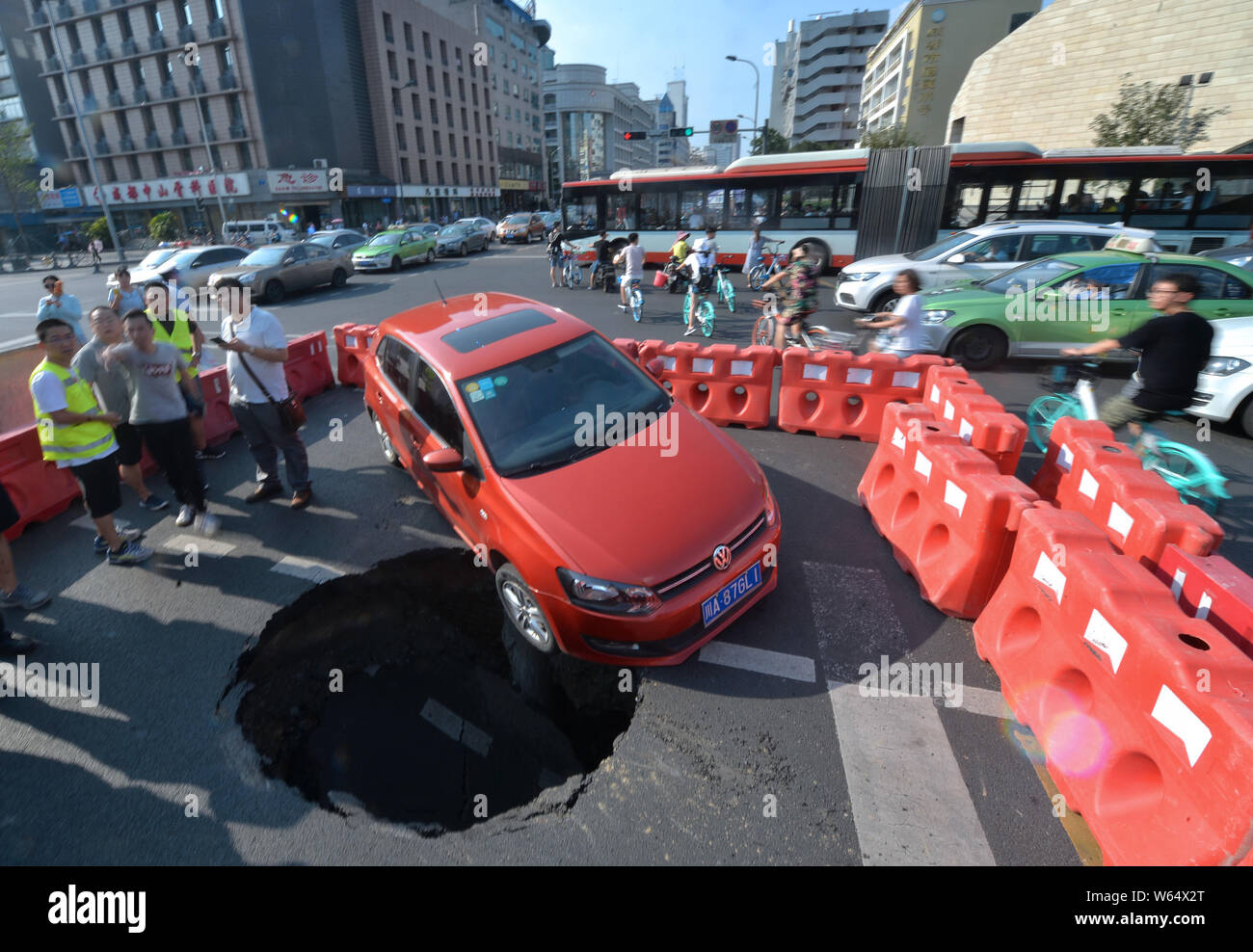 Un véhicule est pris au piège dans un gouffre après l'effondrement d'une route dans la ville de Chengdu, dans le sud-ouest de la province chinoise du Sichuan, le 15 août 2018. Un gouffre qui est al Banque D'Images