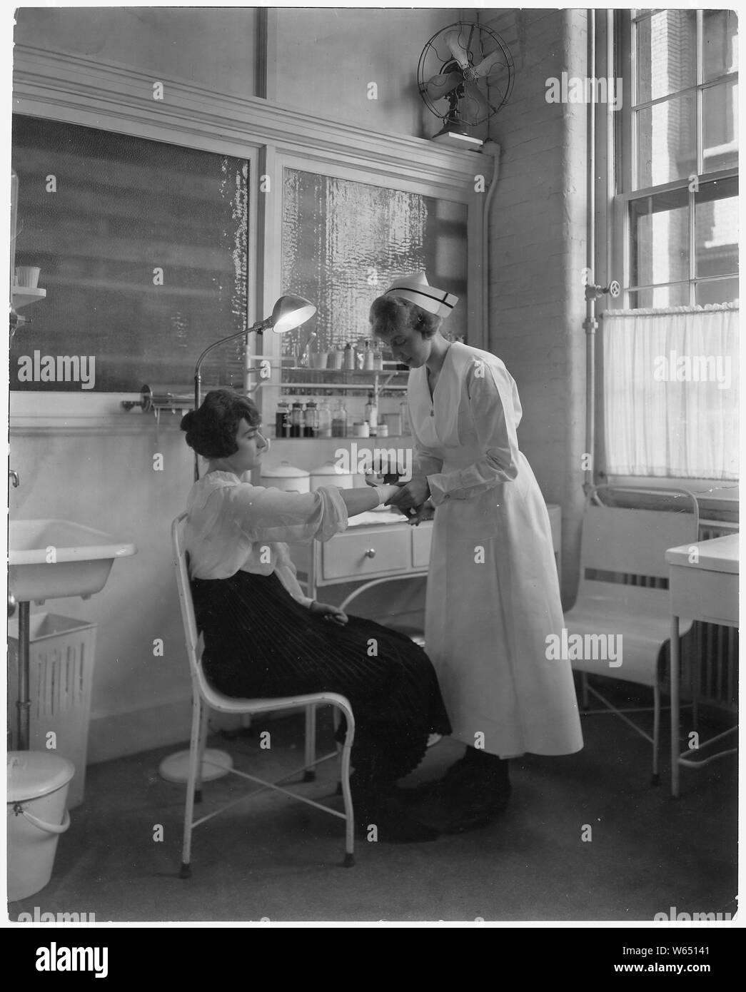 Eastman Kodak Company. Les premiers soins. Woman's arm être pansée par infirmière. Banque D'Images