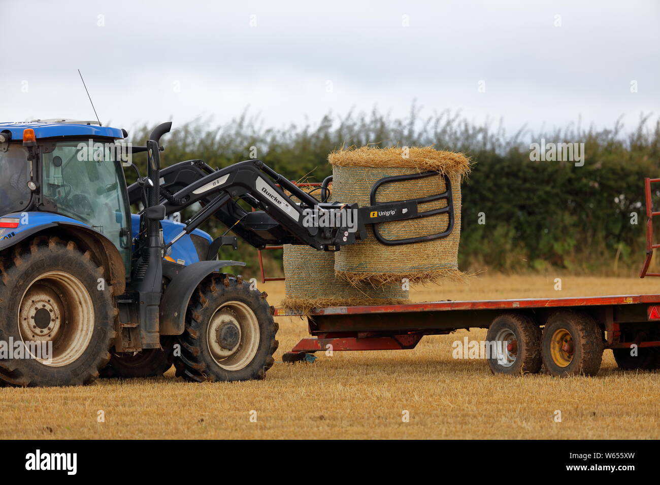 L'agriculteur local lever et déplacer ses bottes de paille sur une