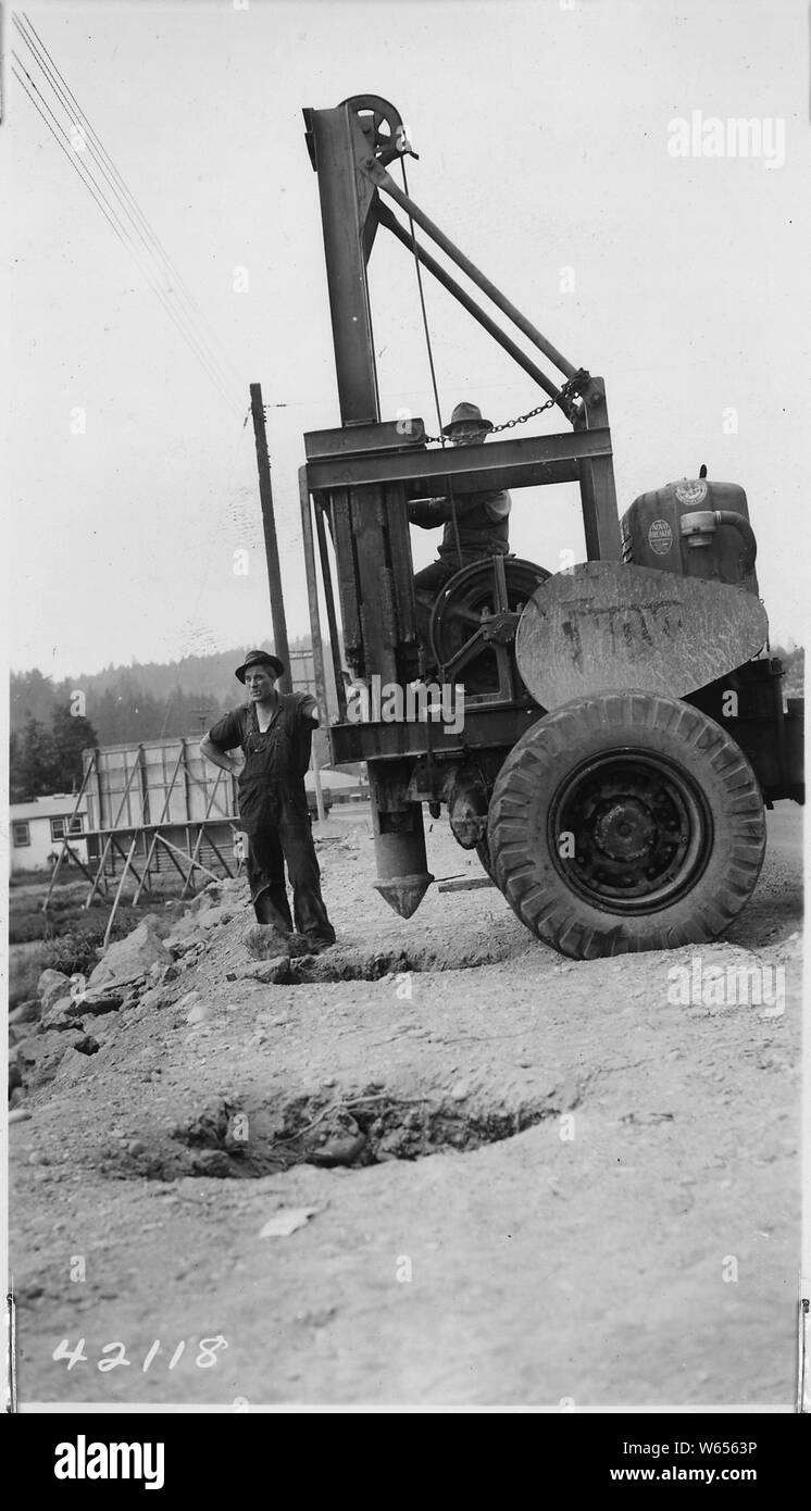 L'équipement utilisé dans les trous le long du bord de l'épaule de frappe pour des poteaux en béton de contre-rail. L'équipement dans la chaussée avec disjoncteur Novo poiint de conduite fixée à 3000 N° d'un marteau. Trous 35-50 conduit chaque jour par deux membres d'équipage. Matériau rocheux où les trous sont entraînés. ; la portée et contenu : la route fédérale pour la route no 21 de l'état primaire, Tidewater Creek à Bremerton Article . Banque D'Images