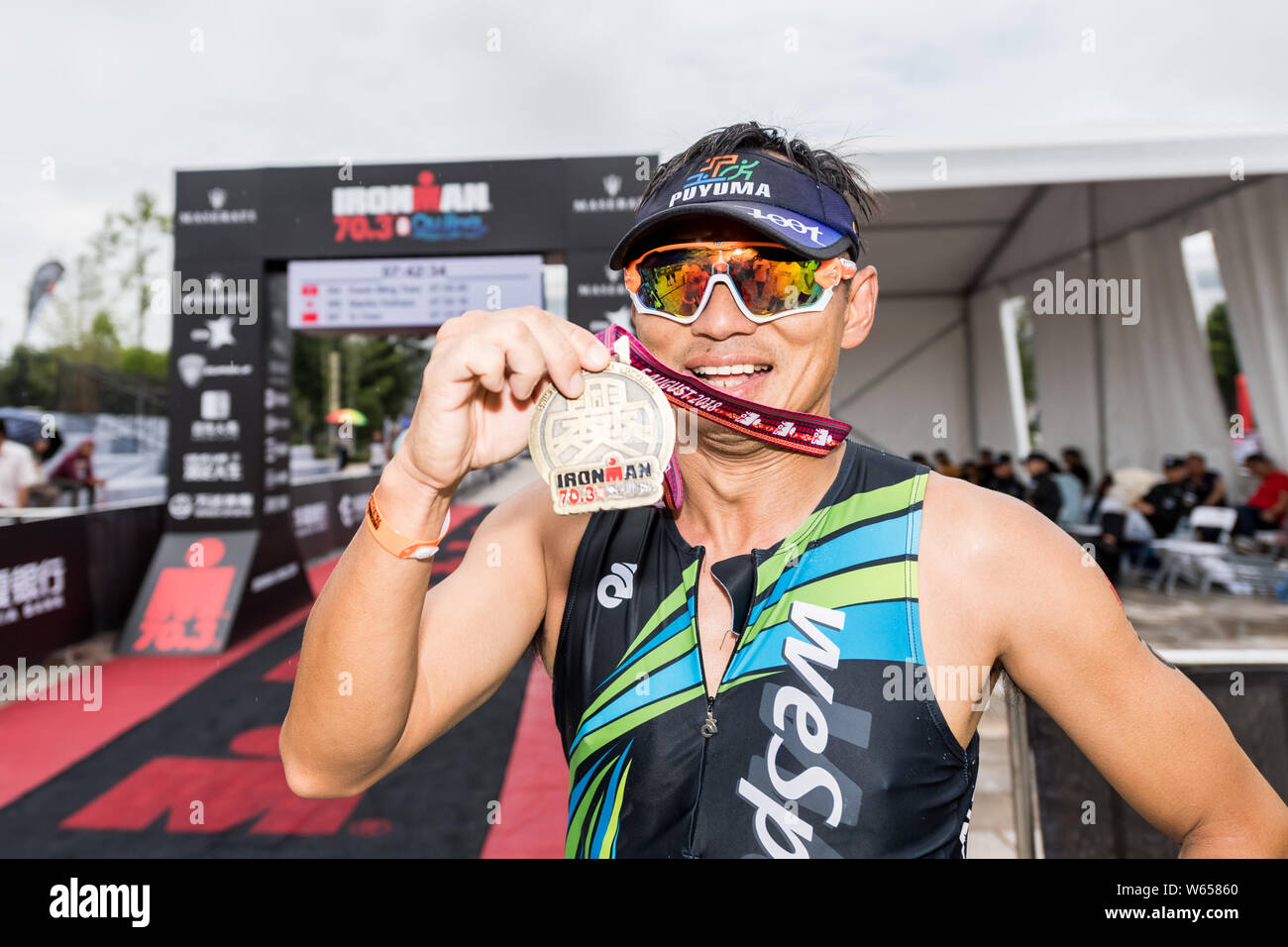 Un triathlète amateur montre sa médaille de après la ligne d'arrivée par fringant au cours de 2018 Ironman 70.3 Qujing dans Qujing toilettte, sud-ouest de la Chine" Banque D'Images