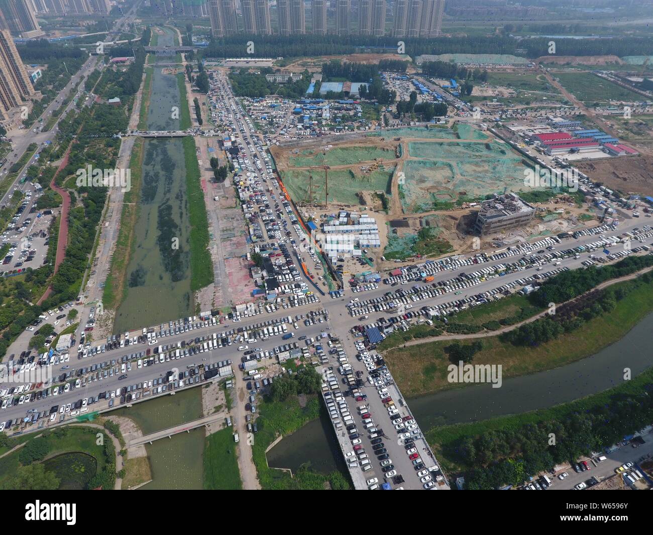Dans cette vue aérienne, des centaines de voitures usagées sont alignés sur les routes, ce qui influe sur la circulation, dans la ville de Zhengzhou, Henan en Chine centrale Banque D'Images