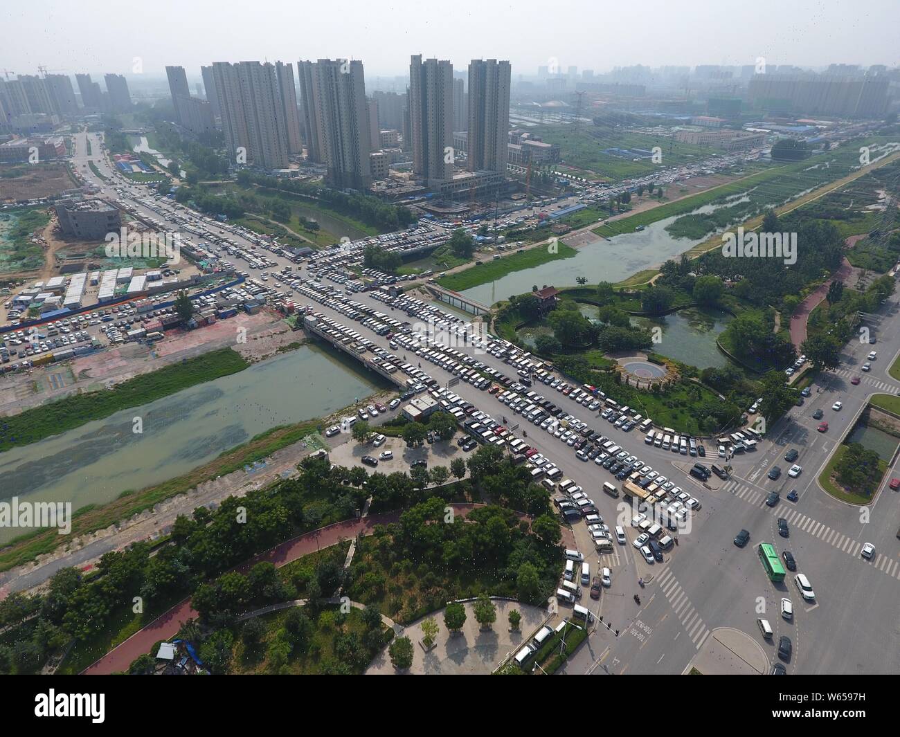 Dans cette vue aérienne, des centaines de voitures usagées sont alignés sur les routes, ce qui influe sur la circulation, dans la ville de Zhengzhou, Henan en Chine centrale Banque D'Images
