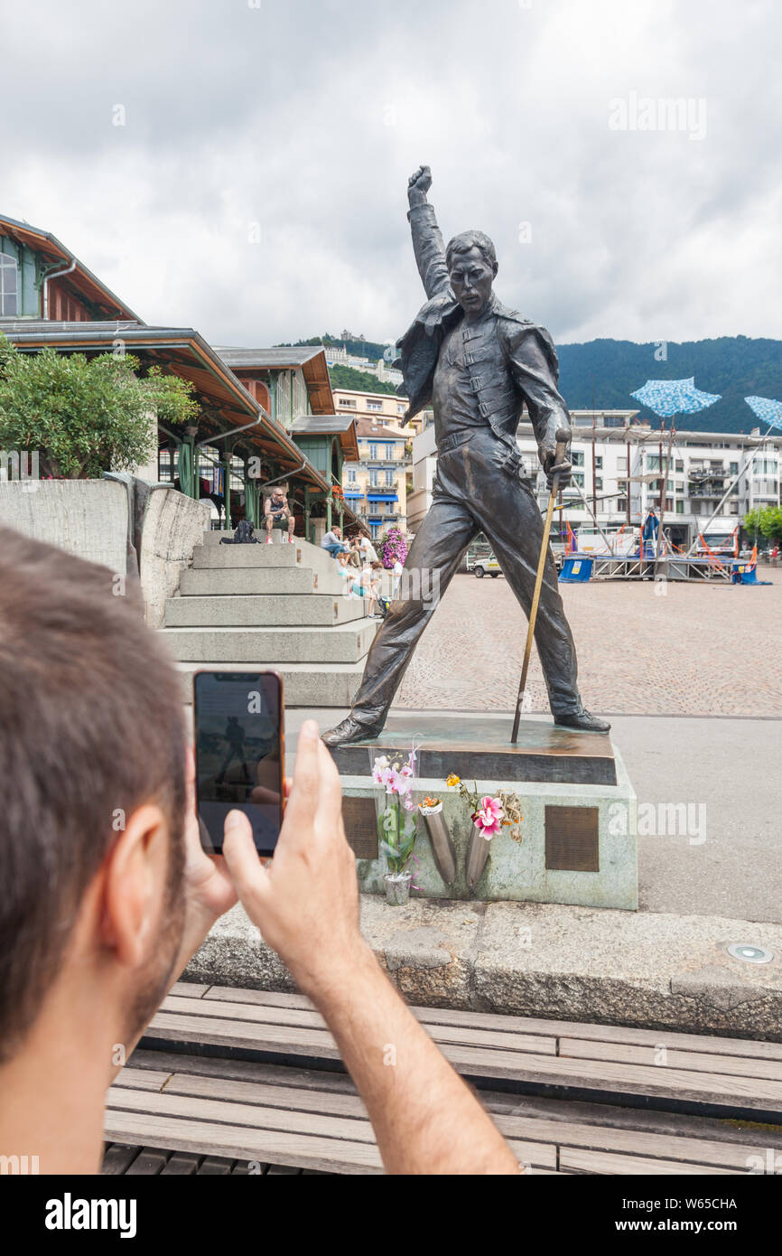 Jeune homme taking photo de la célèbre statue de Freddie Mercury sur la place du marché en face du lac de Genève (lac Léman à Montreux, Vaud, Suisse Banque D'Images