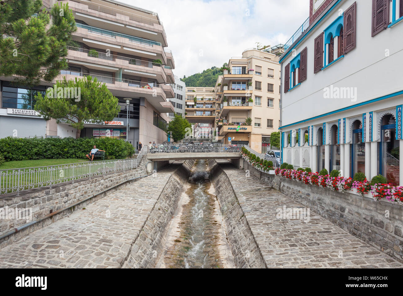 Cours d'eau étroit coulant par riverbed pavée en pierre construit pour protéger des inondations dans la ville de Montreux, Vaud, Suisse durant les somme Banque D'Images