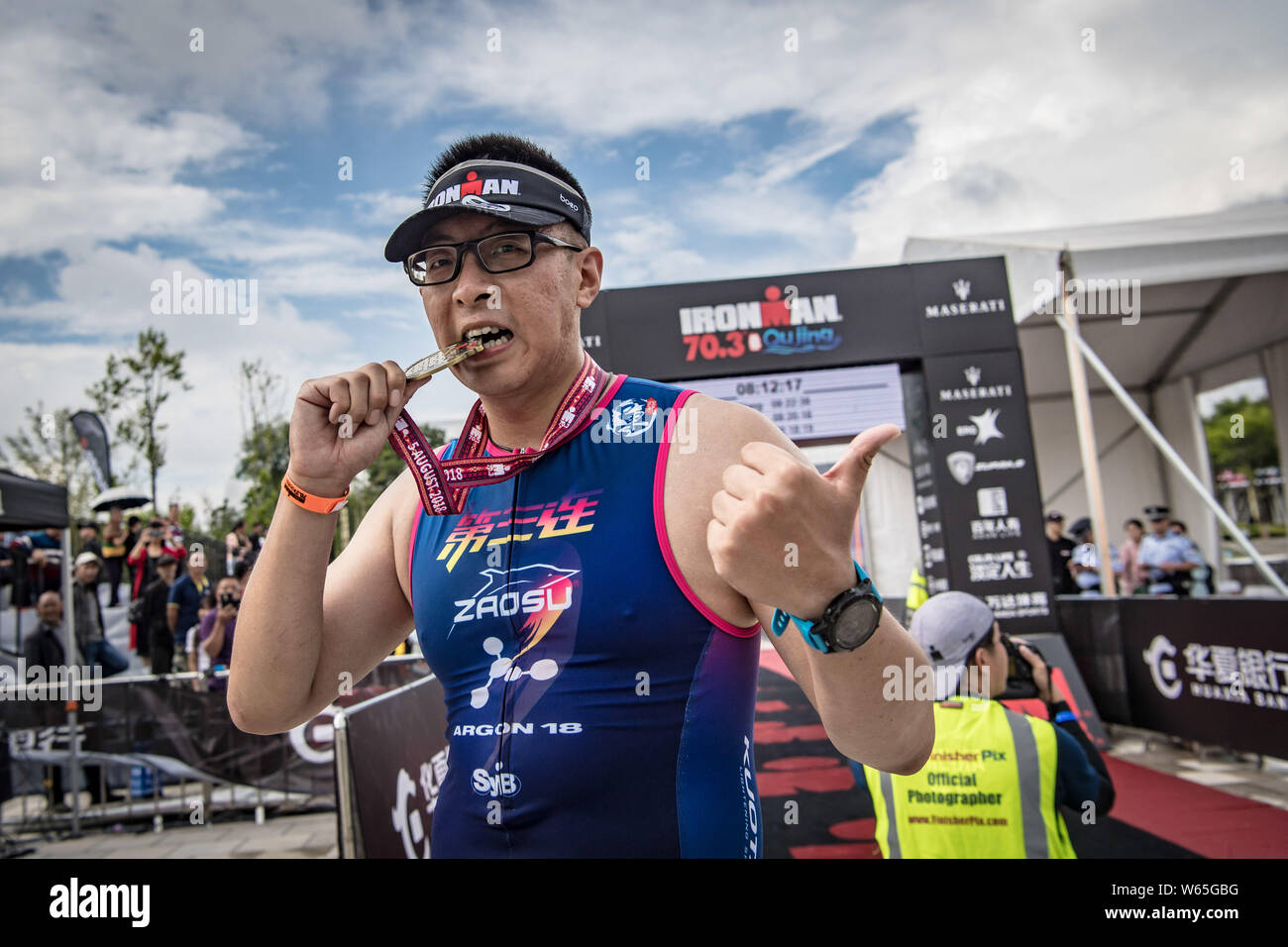 Triathlète Amateur Wang Chuan de la Chine pose avec sa médaille de après la ligne d'arrivée par fringant au cours de 2018 Ironman 70.3 Qujing dans Qujing c Banque D'Images