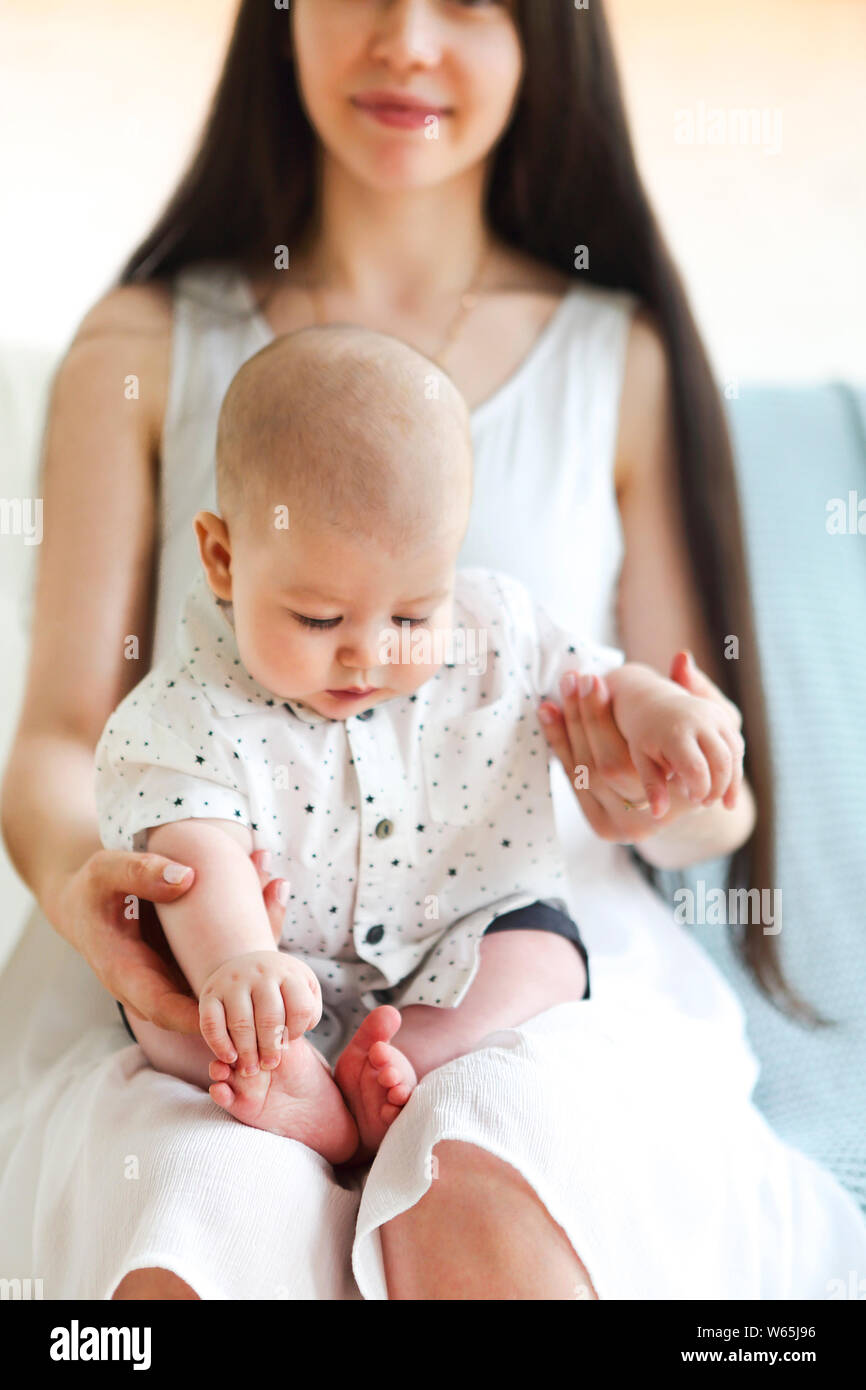 Jeune belle mère holding sweet baby boy sur ses mains Banque D'Images