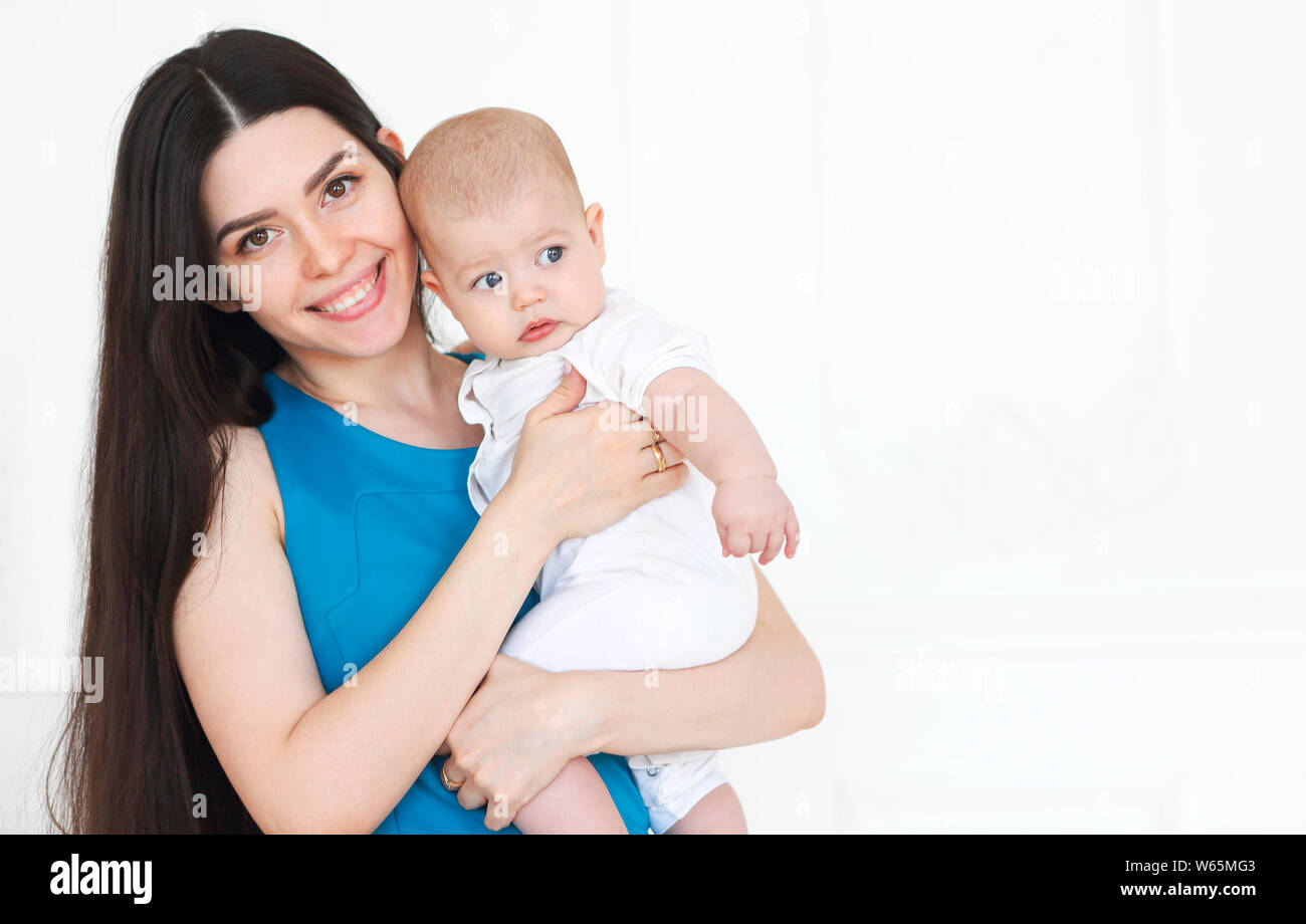 Jeune belle mère holding sweet baby boy sur ses mains Banque D'Images