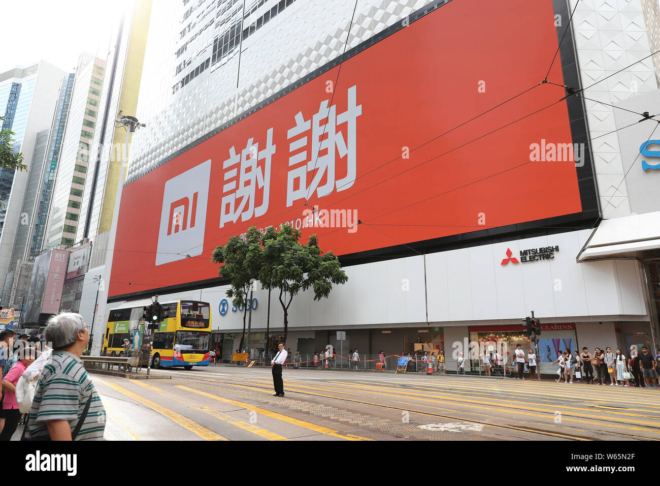 --FILE--piétons traverser une rue en face d'un magasin Xiaomi à Hong Kong, Chine, 11 juillet 2018. Fabricant de Smartphone Xiaomi Corp. a déclaré un bénéfice net Banque D'Images