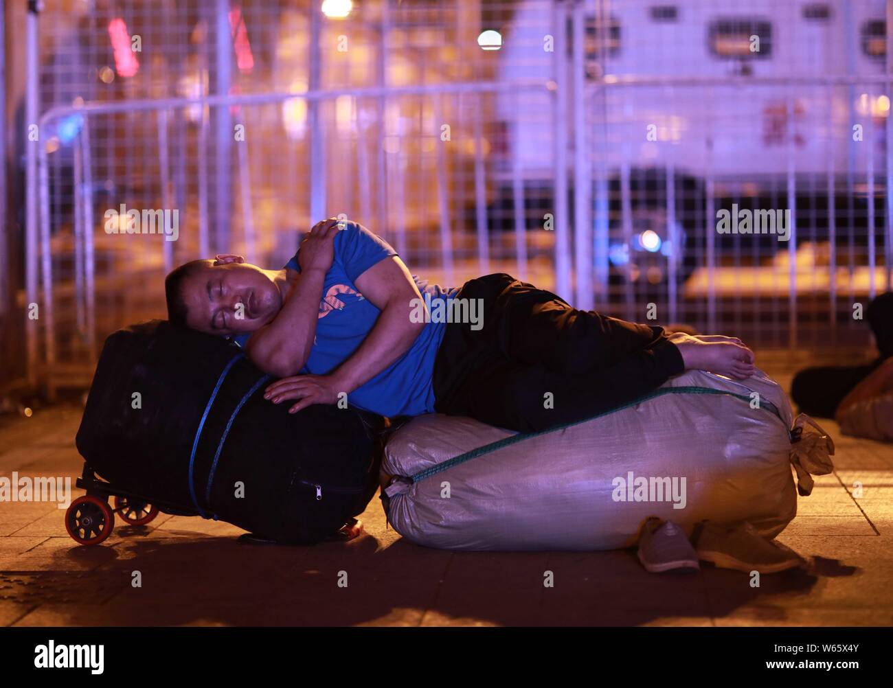 Un Chinois qui peut accueillir et attend son train à la place de la gare de Pékin à Beijing, Chine, 18 août 2018. Les passagers chinois sl Banque D'Images