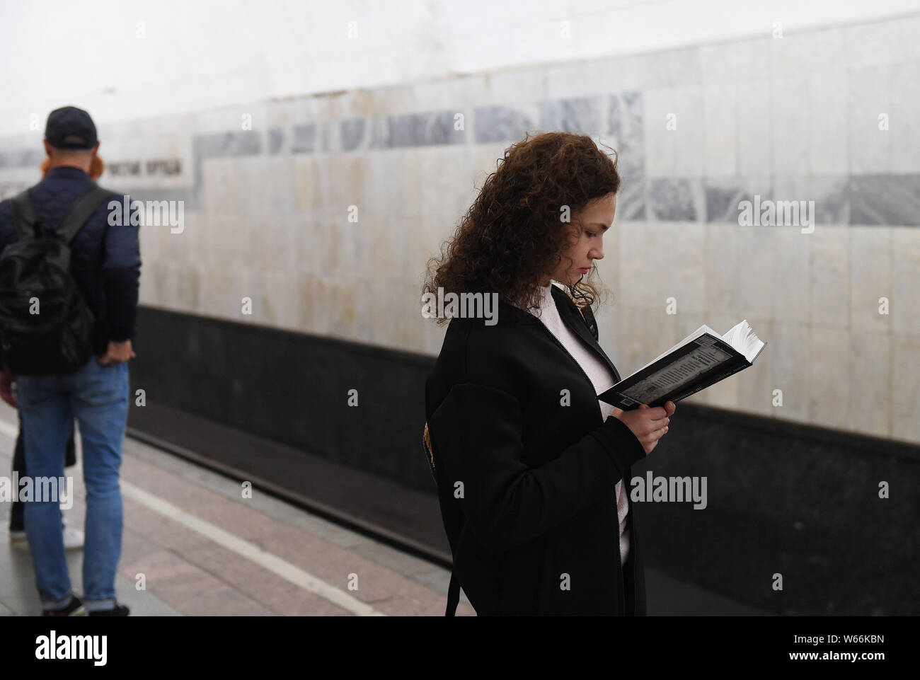 Un frontalier lit un livre, alors qu'elle attend une rame de métro dans une station de métro de Moscou à Moscou, Russie, le 4 juillet 2018. Le métro de Moscou est l'un des Banque D'Images Un frontalier lit un livre, alors qu'elle attend une rame de métro dans une station de métro de Moscou à Moscou, Russie, le 4 juillet 2018. Le métro de Moscou est l'un des Banque D'Images