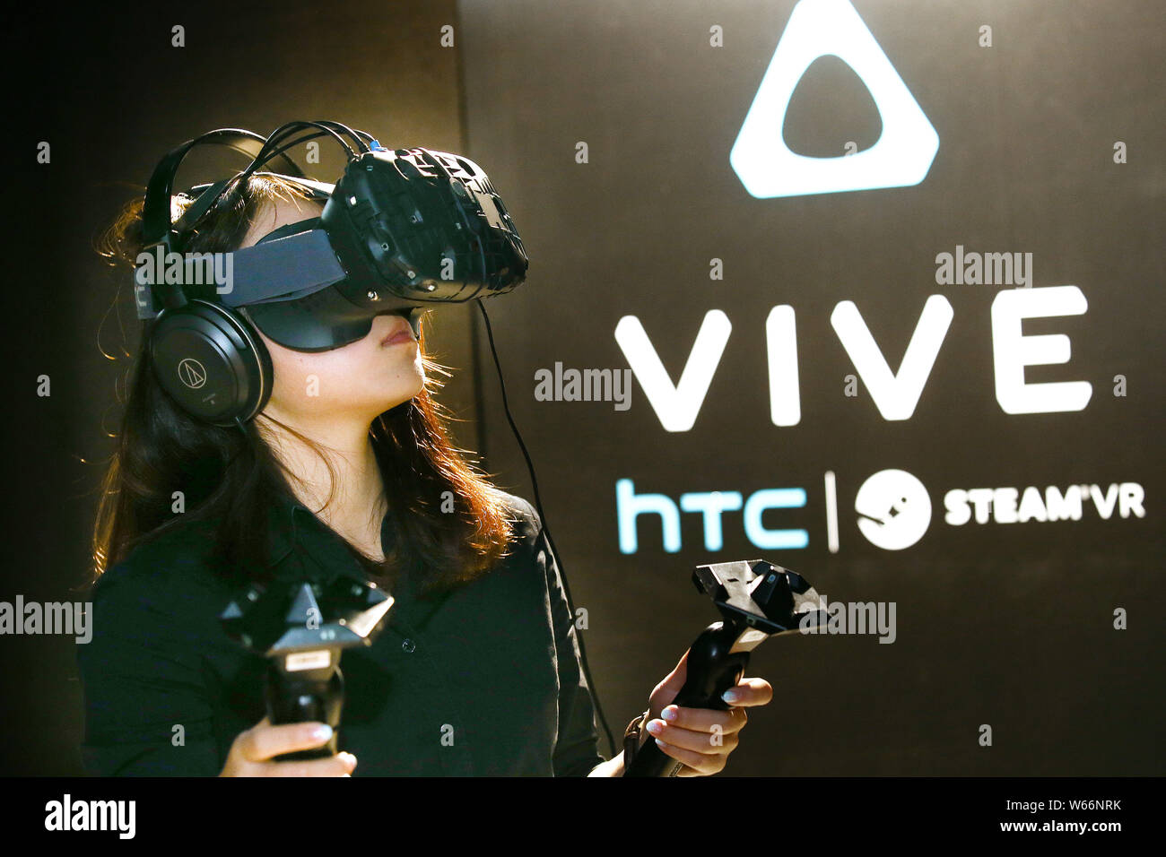 FILE--un syndicat porte un 'Vive' la Réalité Virtuelle (RV) avec casque VR  les contrôleurs de jeu par le taïwanais HTC, lors d'une présentation de  l'entreprise Photo Stock - Alamy