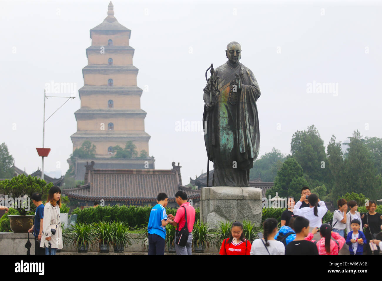 Une statue de bronze de moine bouddhiste chinois Xuanzang se colorer de vert s'affiche en face des Giant Wild Goose Pagoda ou la Grande Pagode de l'Oie Sauvage à Xi'an Banque D'Images