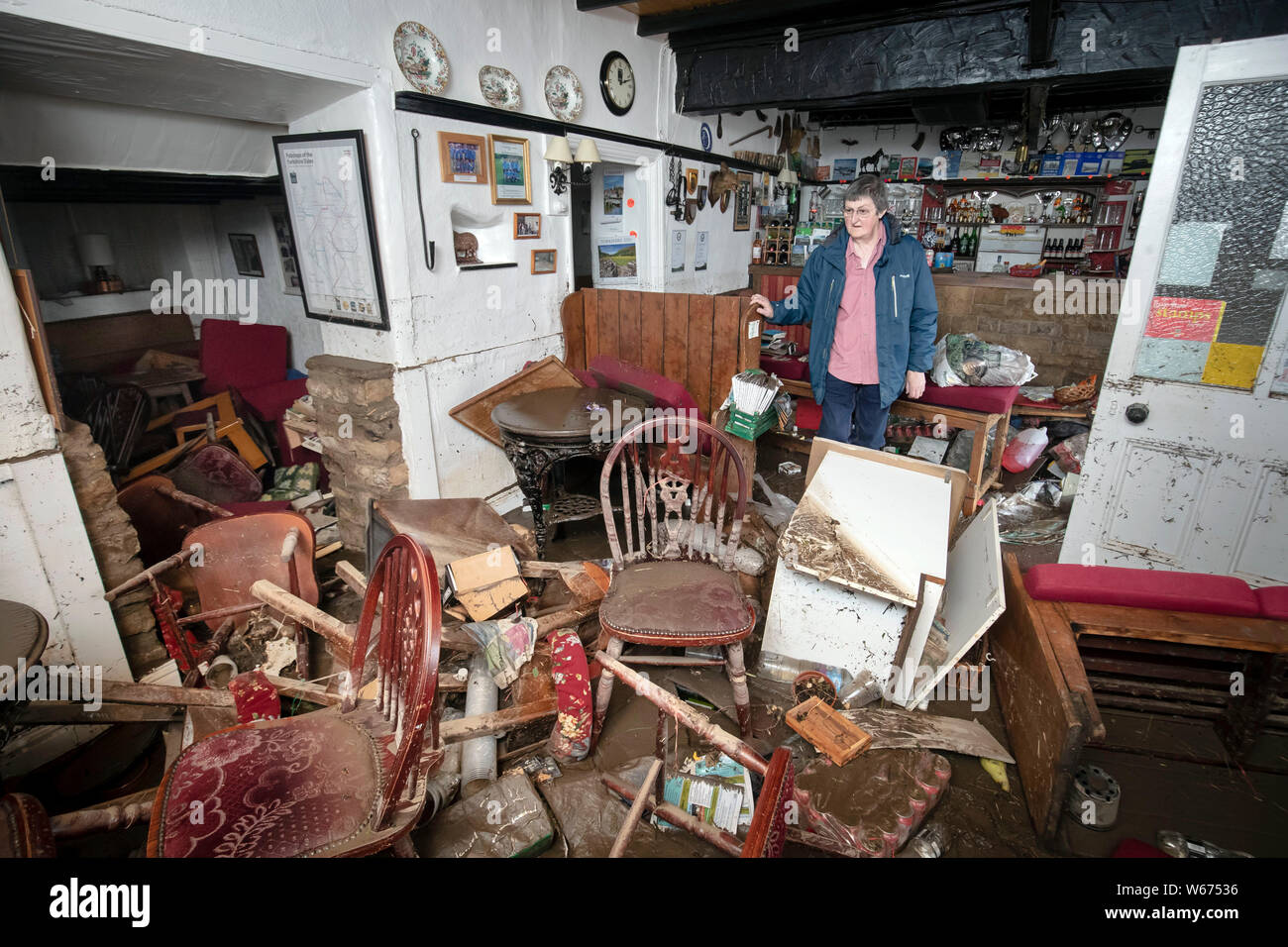 Rowena Hutchinson, propriétaire de l'établissement Red Lion Inn de Langthwaite, Yorkshire du Nord, se dresse dans le bar de sa pub, qui a été dévastée par les eaux de crue, après certaines parties de la région avait 82,2 millions jusqu'à mm de pluie en 24 heures mardi. Banque D'Images