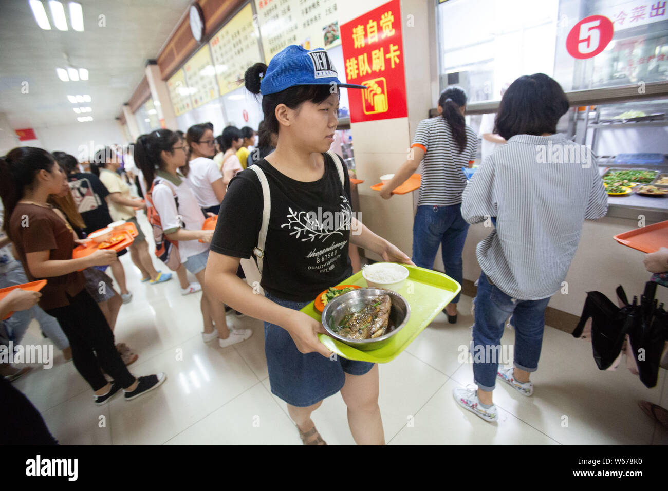 Un étudiant se prépare à profiter gratuitement des plats de poisson, qui sont récoltées à partir de la 210 Daoqian Lake dans le campus de l'Université de médecine de Guangxi, au collège peut Banque D'Images