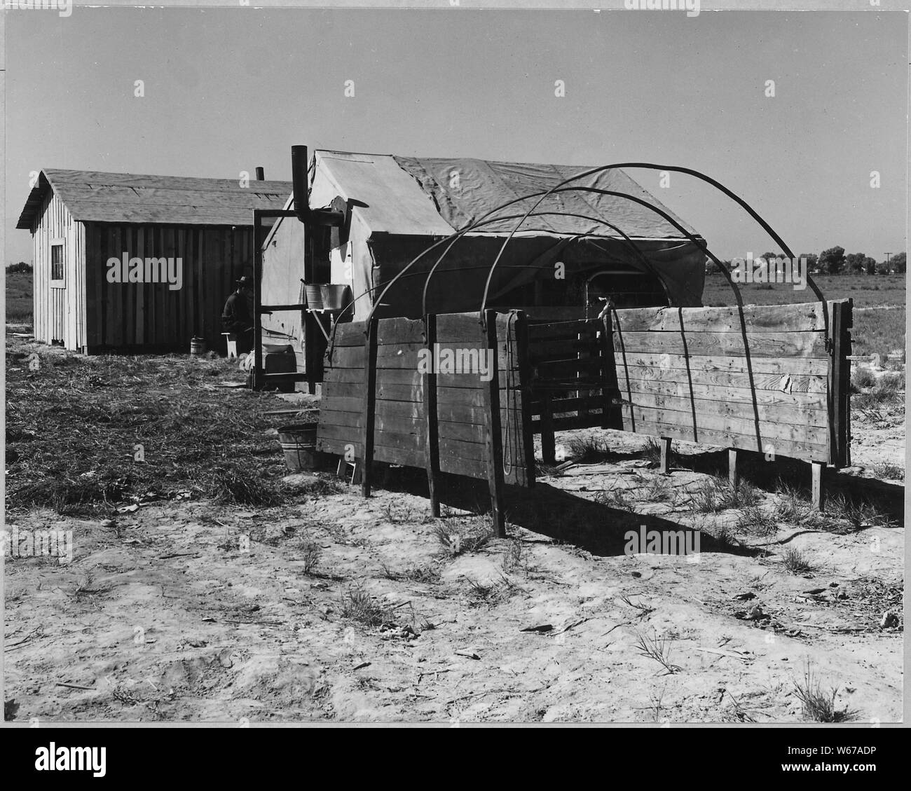 McNews, près de Bakersfield, comté de Kern, en Californie. Dans McNews subdivision. La famille de l'Ouest, quatre rela . . . ; Portée et contenu : la légende complète se lit comme suit : McNews, près de Bakersfield, comté de Kern, en Californie. Dans McNews subdivision. La famille de l'Ouest, quatre familles voyageant ensemble, gauche Atoka Comté, New York le 2 avril 1940, neuf jours avant la photographie a été faite. La photographie montre les côtés du camion dans lequel ils sont venus sur le terrain. La tente qu'ils ont érigé et la nouvelle cabine qui ils ont construit par leur propre main sur un morceau de terre pauvre et ce lotissement sur lequel Banque D'Images