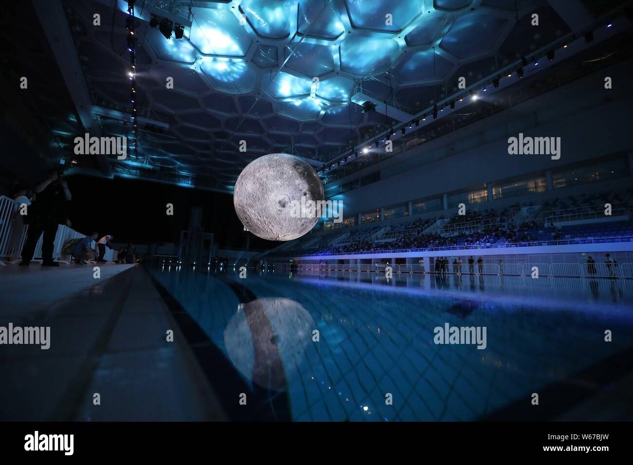 Les visiteurs voir un énorme modèle lune lors d'une exposition sur la lune au Centre aquatique ou 'Cube d'eau" à Beijing, Chine, 8 juillet 2018. Un Banque D'Images