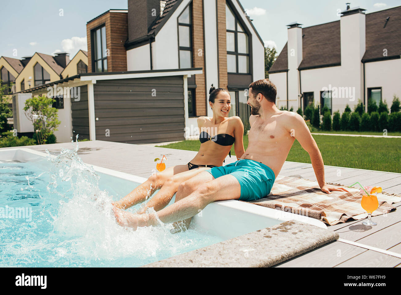 Homme et une femme regarder amoureusement à l'autre tandis que dans la piscine. Au revoir, bonjour les vacances d'été de natation et de bronzage Banque D'Images
