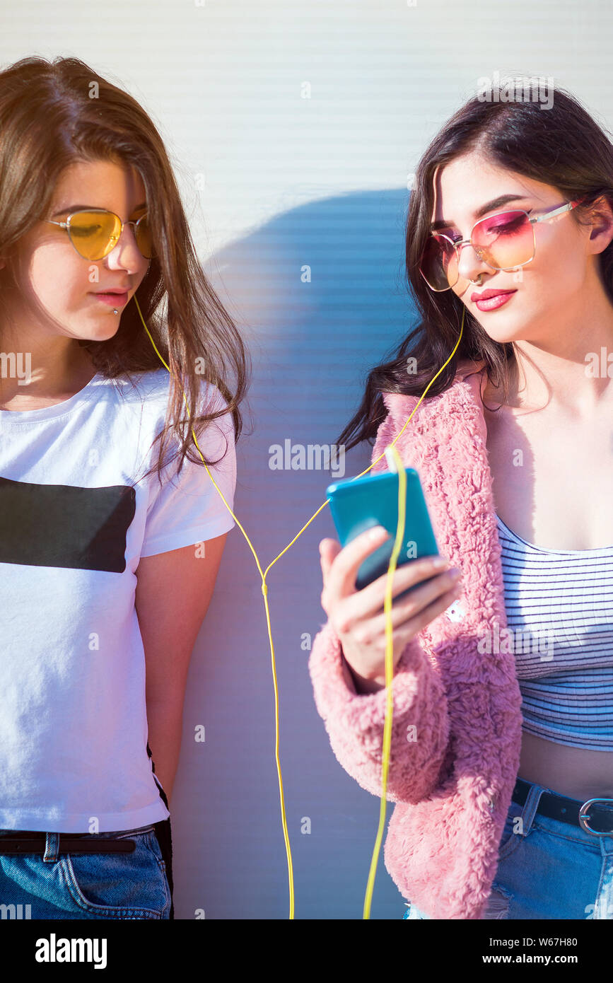Deux jeunes femmes friends sharing headphones Banque D'Images