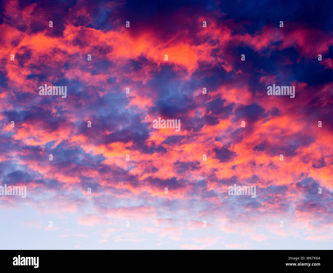 Ciel au coucher du soleil avec nuages orange/rose Banque D'Images