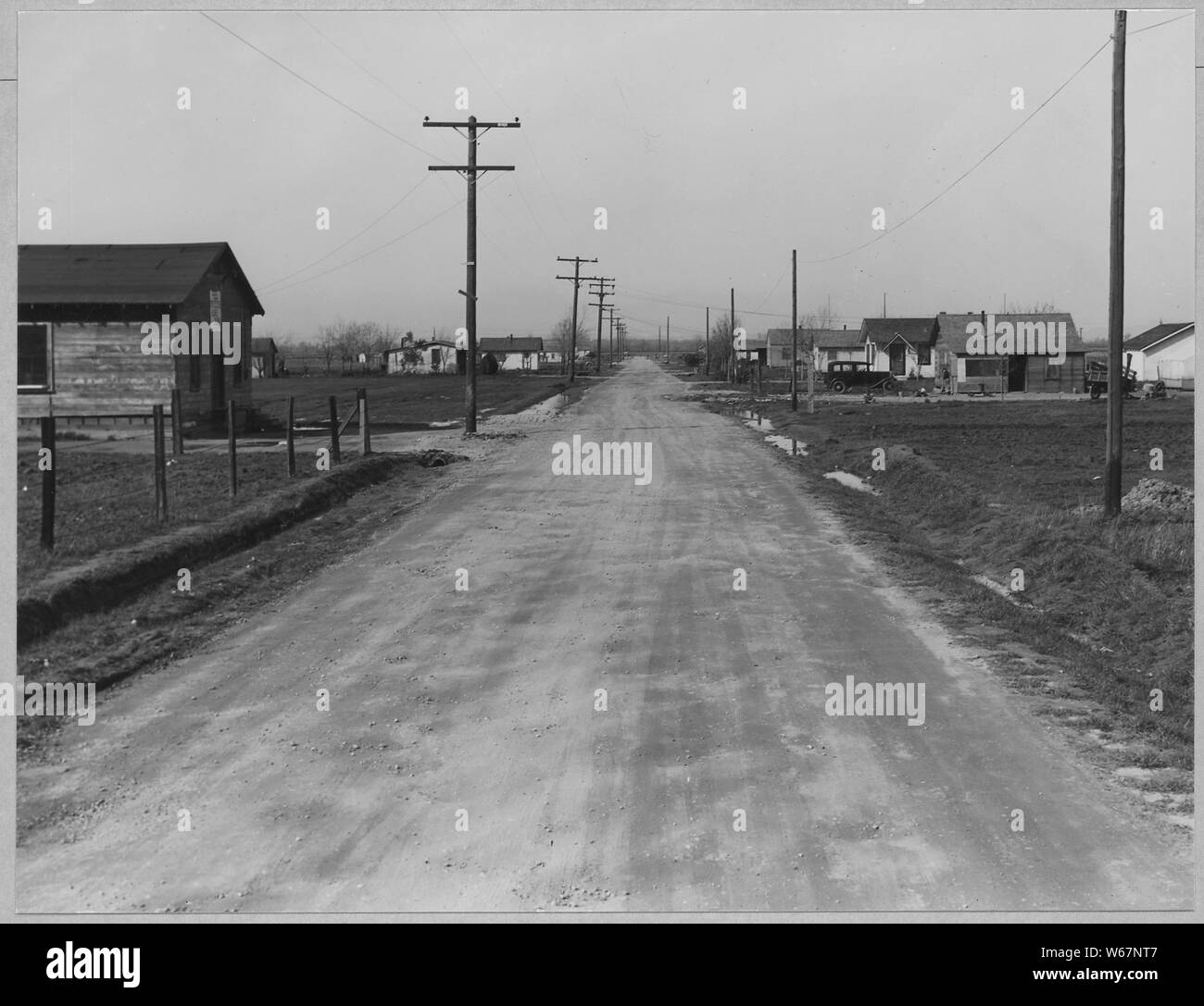 Olivehurst, Yuba County, en Californie. En regardant la 2e Avenue à partir de Olivehurst à l'ouest. Ce st . . . ; Portée et contenu : la légende complète se lit comme suit : Olivehurst, Yuba County, en Californie. En regardant la 2e Avenue à partir de Olivehurst à l'ouest. Cette rue comporte 26 maisons, qui ont tous été photographiés. La première maison sur la gauche est l'église. Remarque la rue non revêtues et les lignes électriques qui a de l'électricité récemment. Banque D'Images