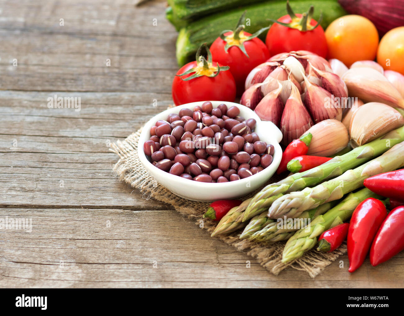 Les haricots azuki dans un bol et les légumes sur la table en bois Banque D'Images